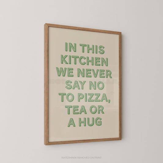 A framed typographic wall art print with the phrase “IN THIS KITCHEN WE NEVER SAY NO TO PIZZA, TEA OR A HUG” in green letters on a warm cream background, shown hanging on a light gray wall.