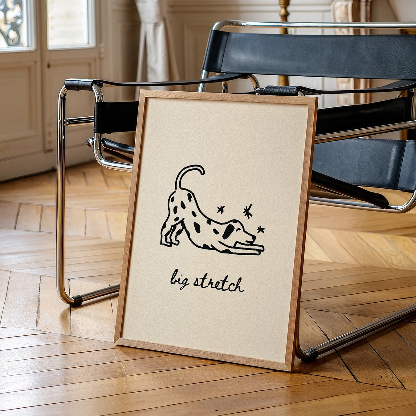 Framed print with a dog illustration and 'big stretch' text on a wooden floor.