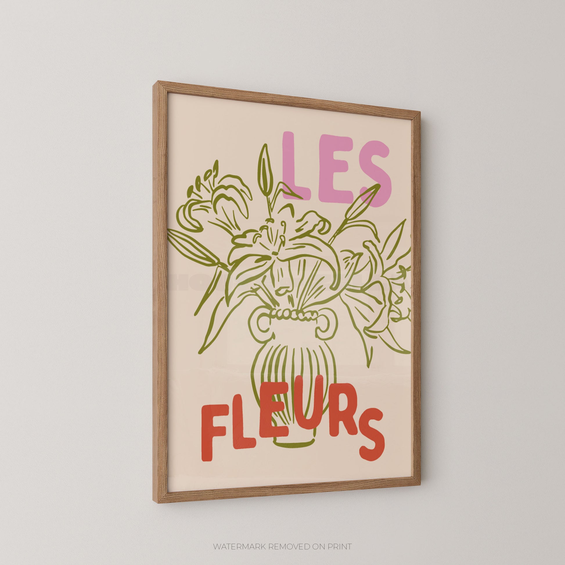 A framed art print featuring a botanical illustration of lilies in a vase with the French text 'LES FLEURS' in pink and red, hanging on a light gray wall.