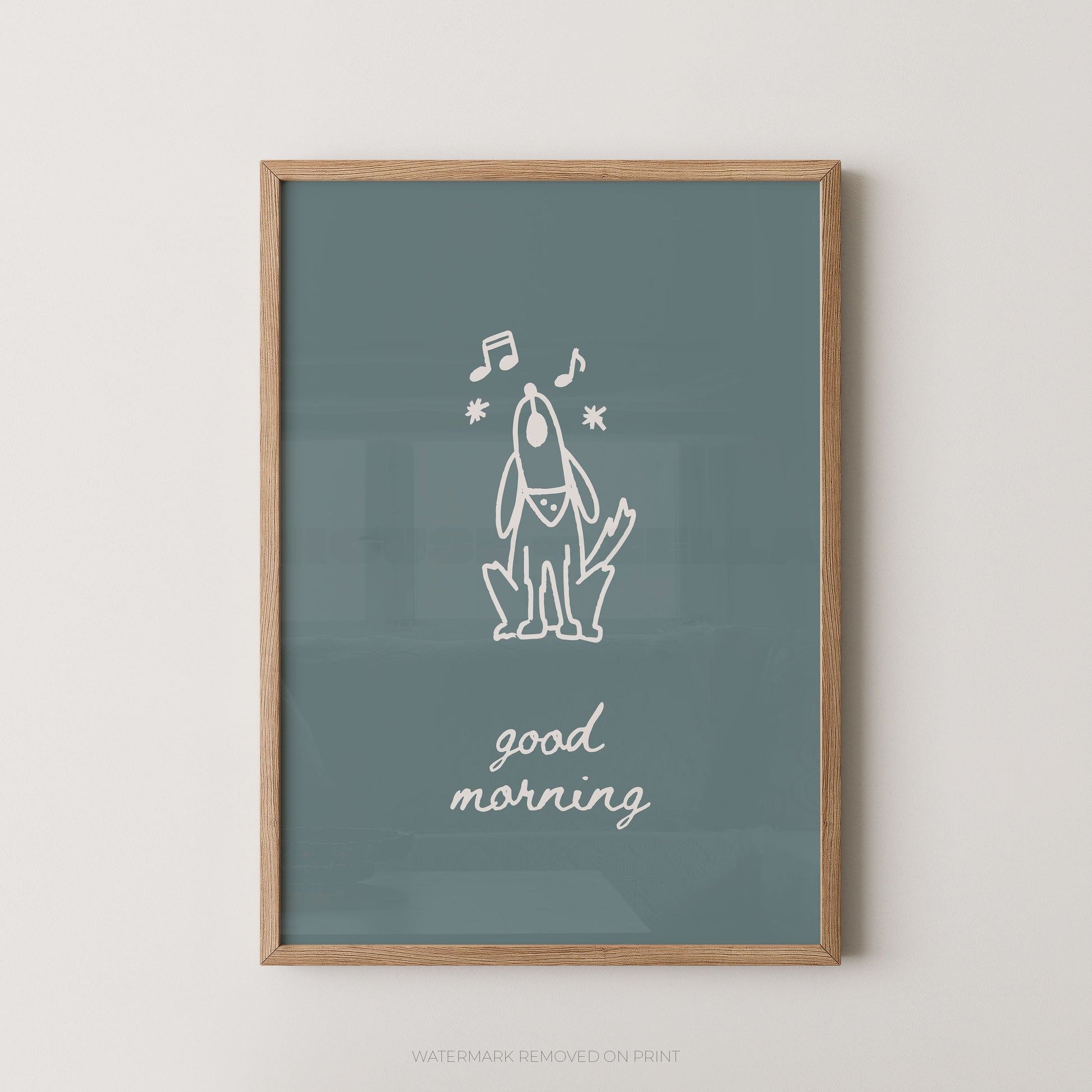 A framed art print featuring a minimalist white line drawing of a dog with musical notes and the text 'good morning' on a muted blue-green background, enclosed in a light wood frame against a neutral wall.