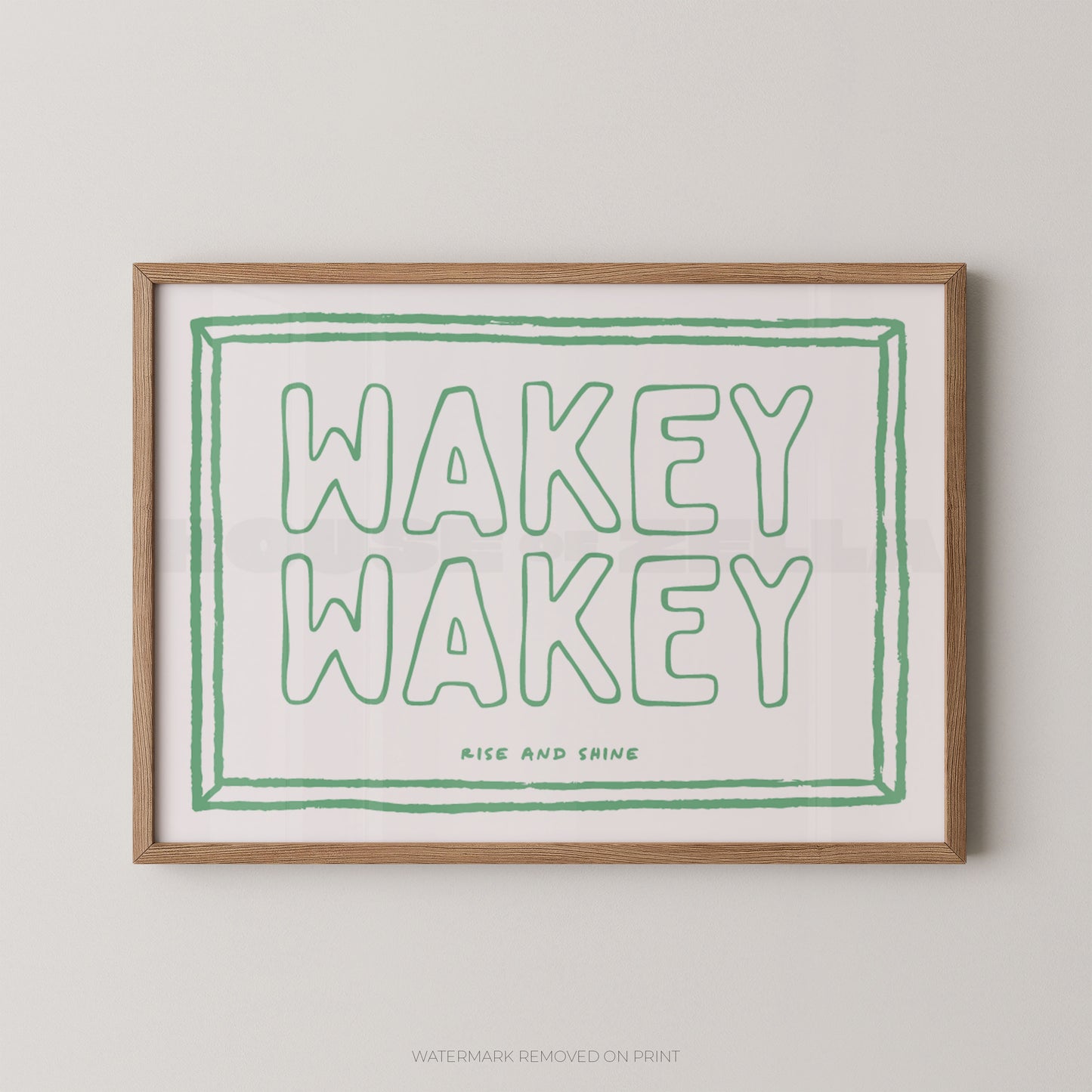 Framed print with 'Wakey Wakey' text in green on a white background