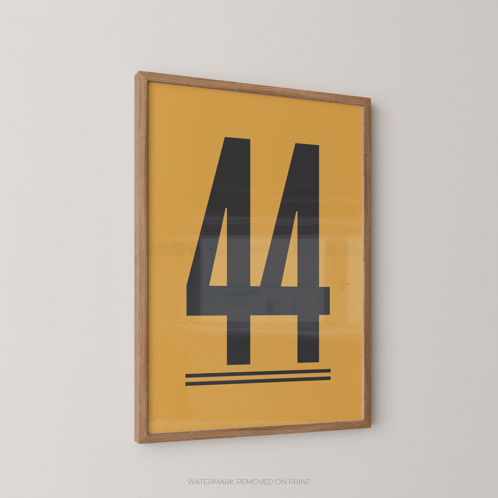 Framed minimalist wall art featuring a large black number 44 on a mustard yellow background, enclosed in a light natural wood frame and shown hanging on a light gray wall.