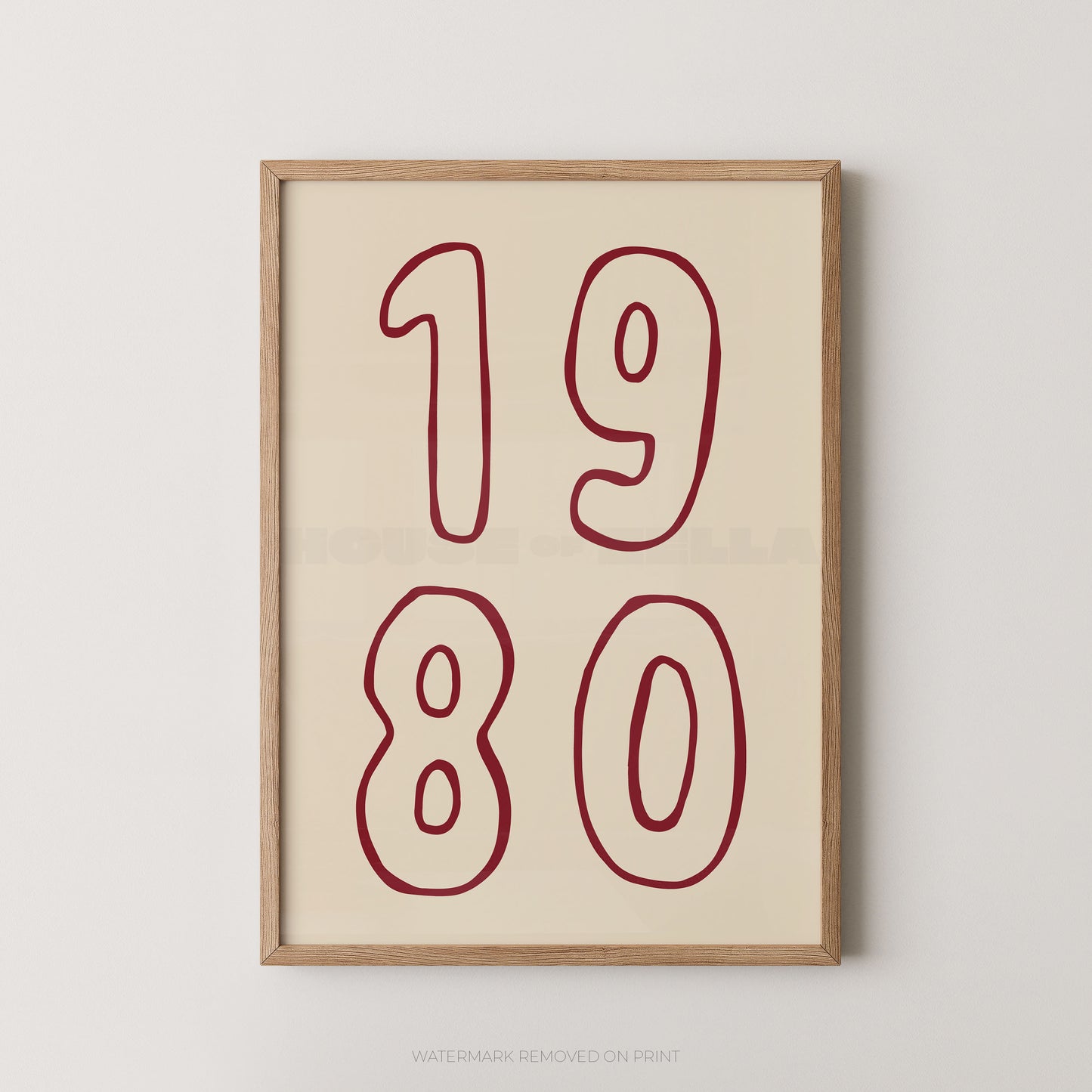 Framed wall art print with the numbers '1980' in dark red outline on a warm cream background, shown in a light natural wood frame against a light gray wall.