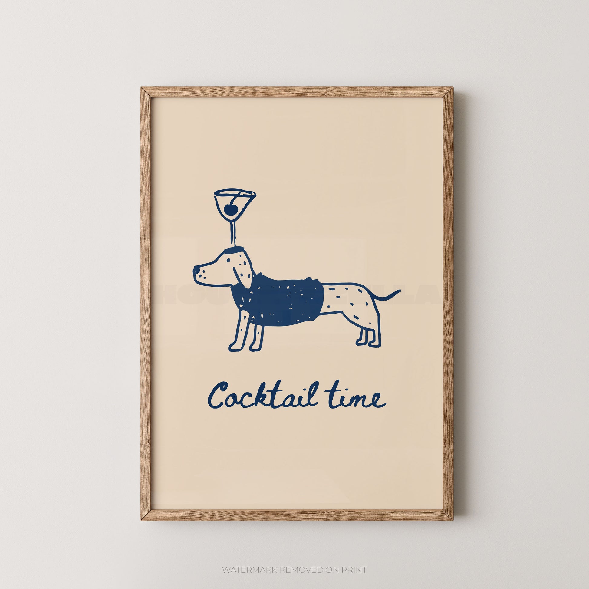 Framed wall art print with a navy blue line drawing of a dachshund wearing a martini glass on its head and the words 'Cocktail time' below, shown in a light wood frame against a light gray wall.