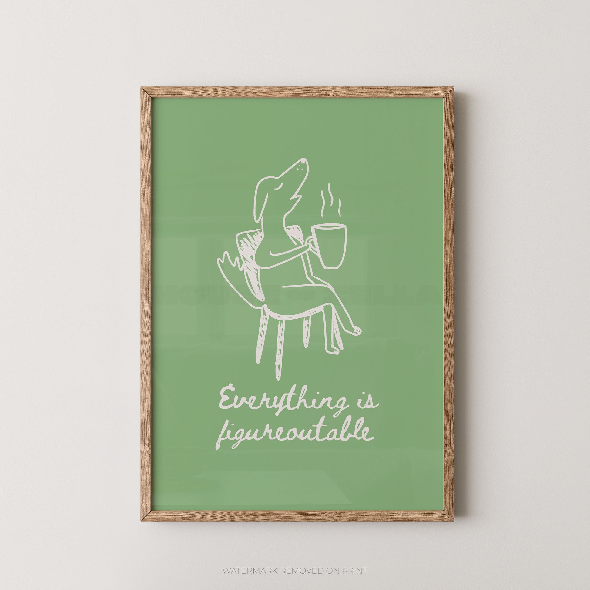 Framed artwork with a white line drawing of a person on a chair holding a cup, against a green background with text, on a light beige wall.