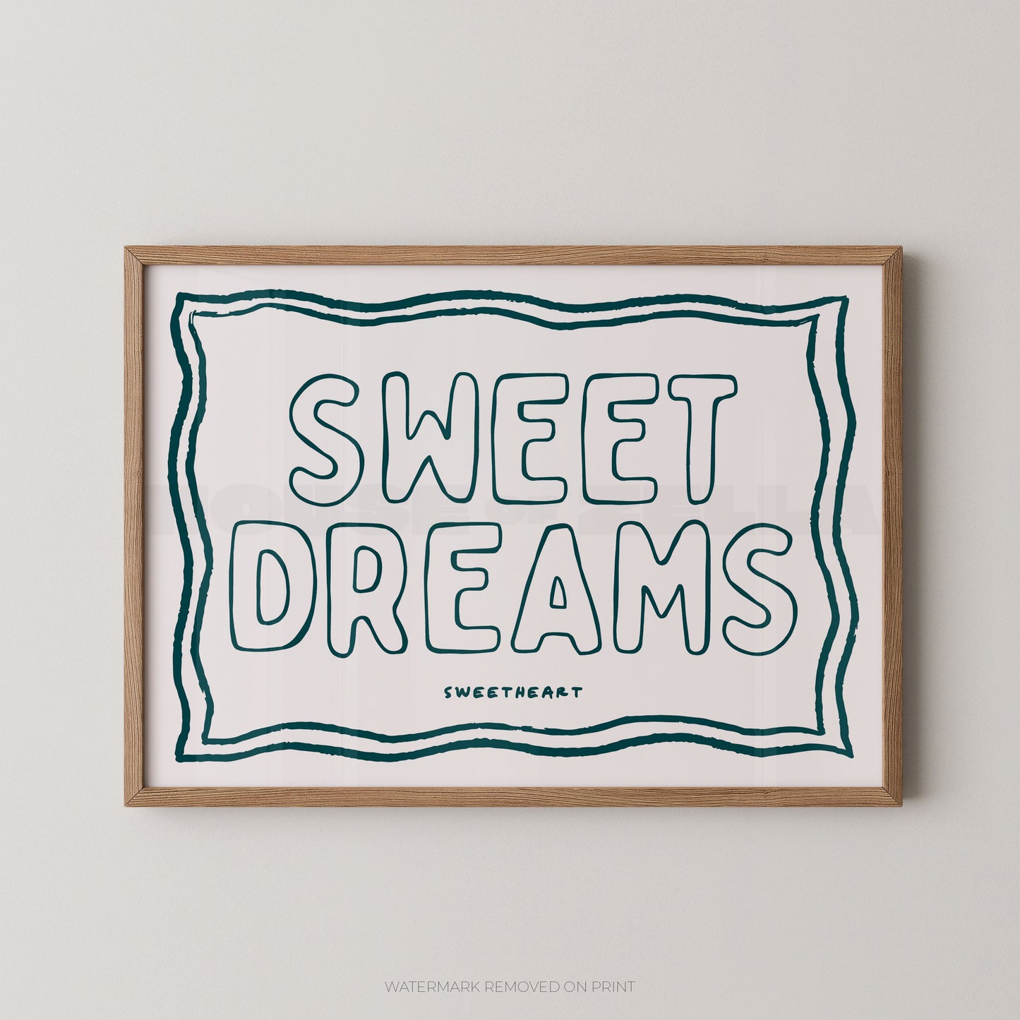 Framed typographic wall art reading “SWEET DREAMS” in outlined teal lettering on a white background, with a thin double-line border and small “SWEETHEART” text below. The print is shown in a light wood frame against a light gray wall.