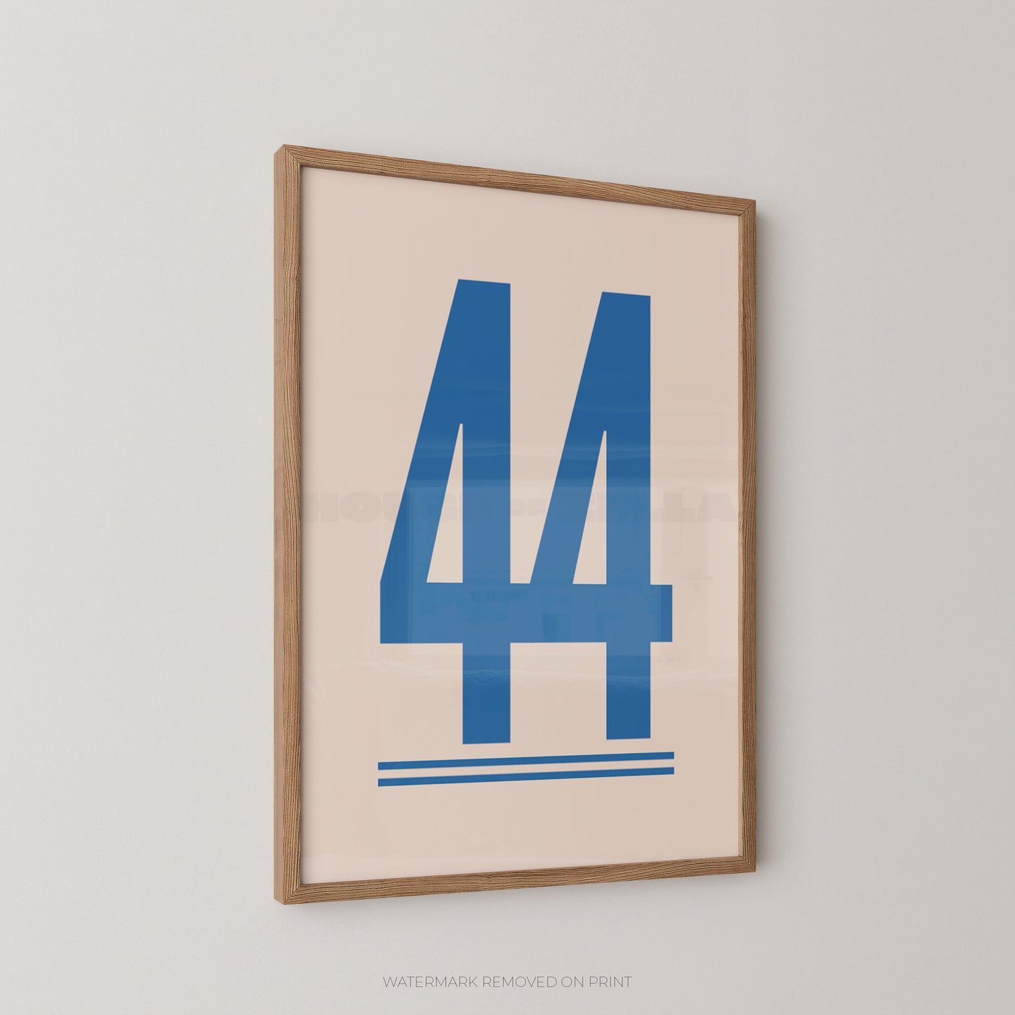 Framed minimalist art print featuring the blue number 44 on a warm cream background, enclosed in a light natural wood frame and shown hanging on a light gray wall.