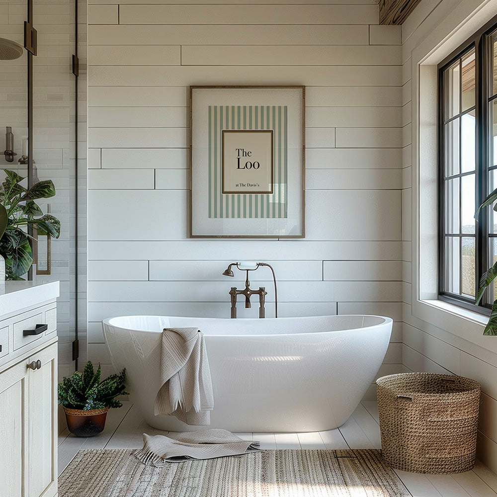 Modern bathroom with freestanding bathtub, framed artwork, and natural light.