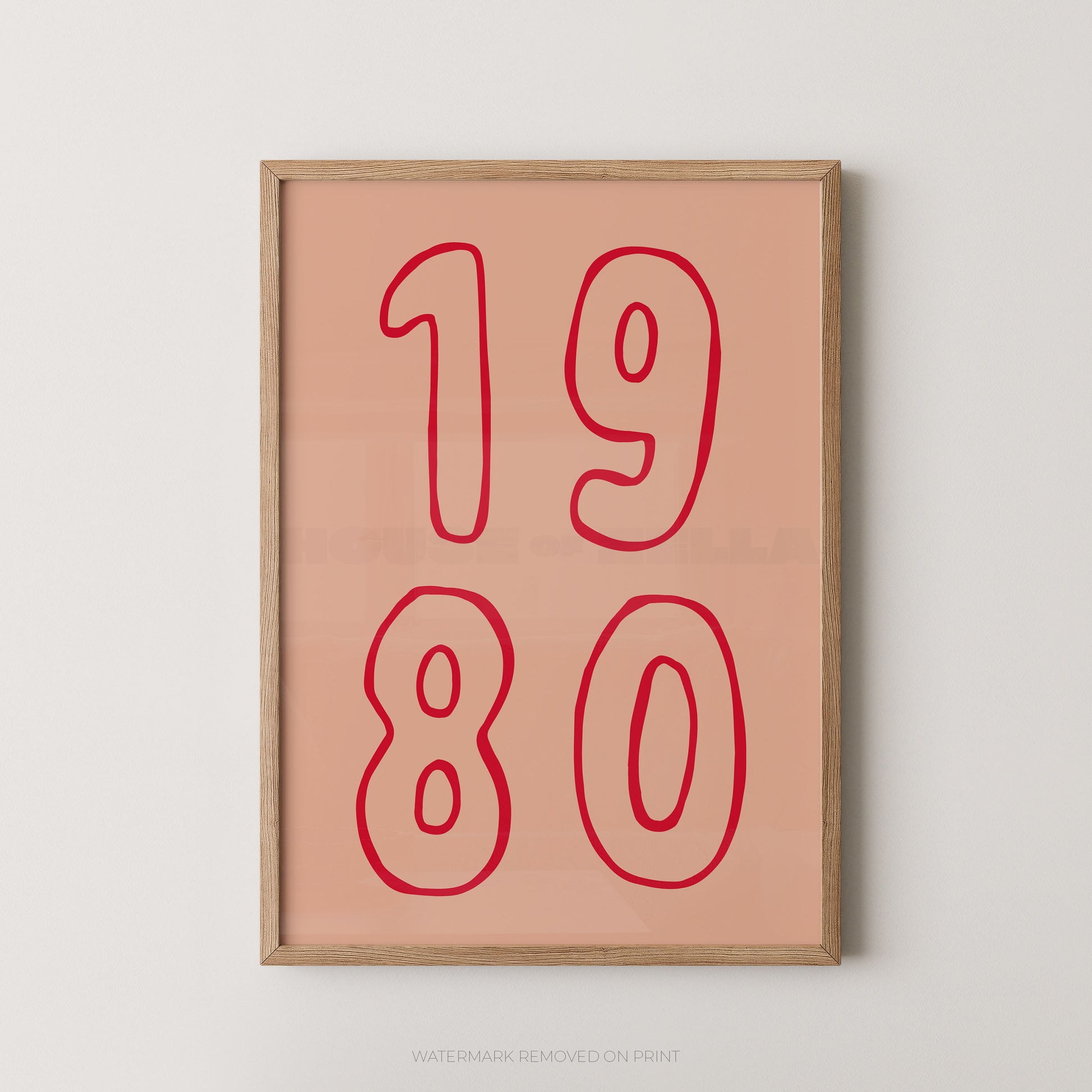 Framed wall art print with the numbers '1980' in red outline on a peach background, shown hanging against a light gray wall.