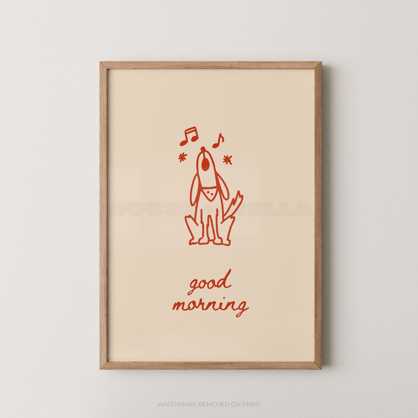 A framed art print featuring a minimalist red line drawing of a dog with musical notes and the words 'good morning' in red script on a warm cream background, enclosed in a light natural wood frame.