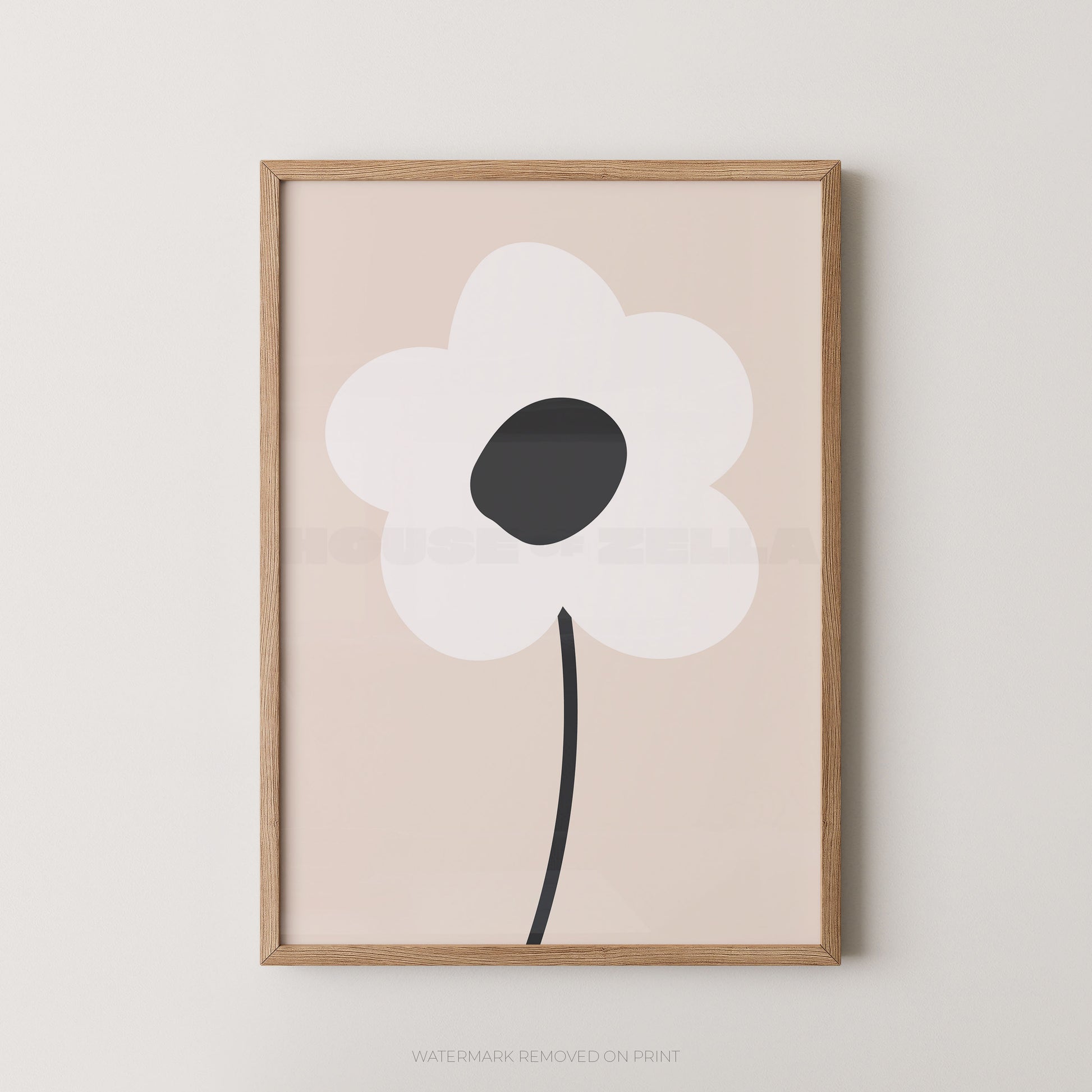 Framed minimalist floral wall art featuring a stylized white flower with a dark gray center and black stem on a pale blush background, set in a light natural wood frame against a neutral wall.