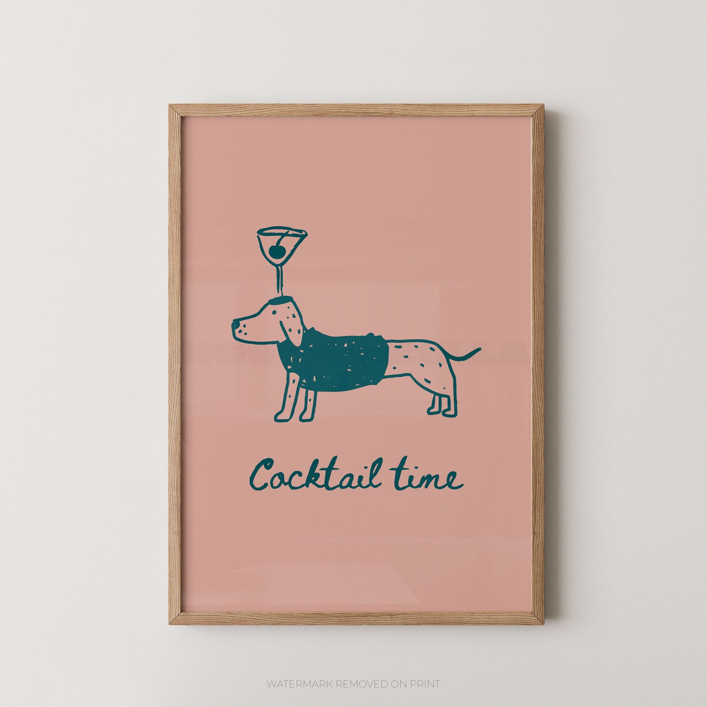 A framed art print featuring a dachshund wearing a dark teal sweater with a cocktail glass on its head, above the text 'Cocktail time' in dark teal, set against a dusty pink background and enclosed in a light wood frame.
