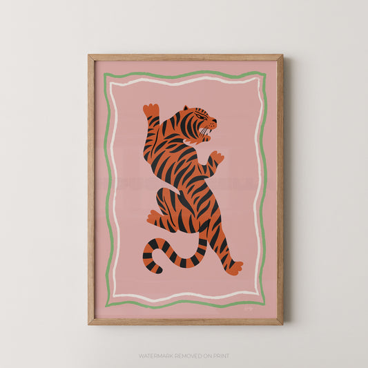 "Tiger Portrait bold graphic wall art print featuring an orange tiger with black stripes in a dynamic pose on a dusky pink background with a green and white wavy border, displayed straight-on in an oak frame"

