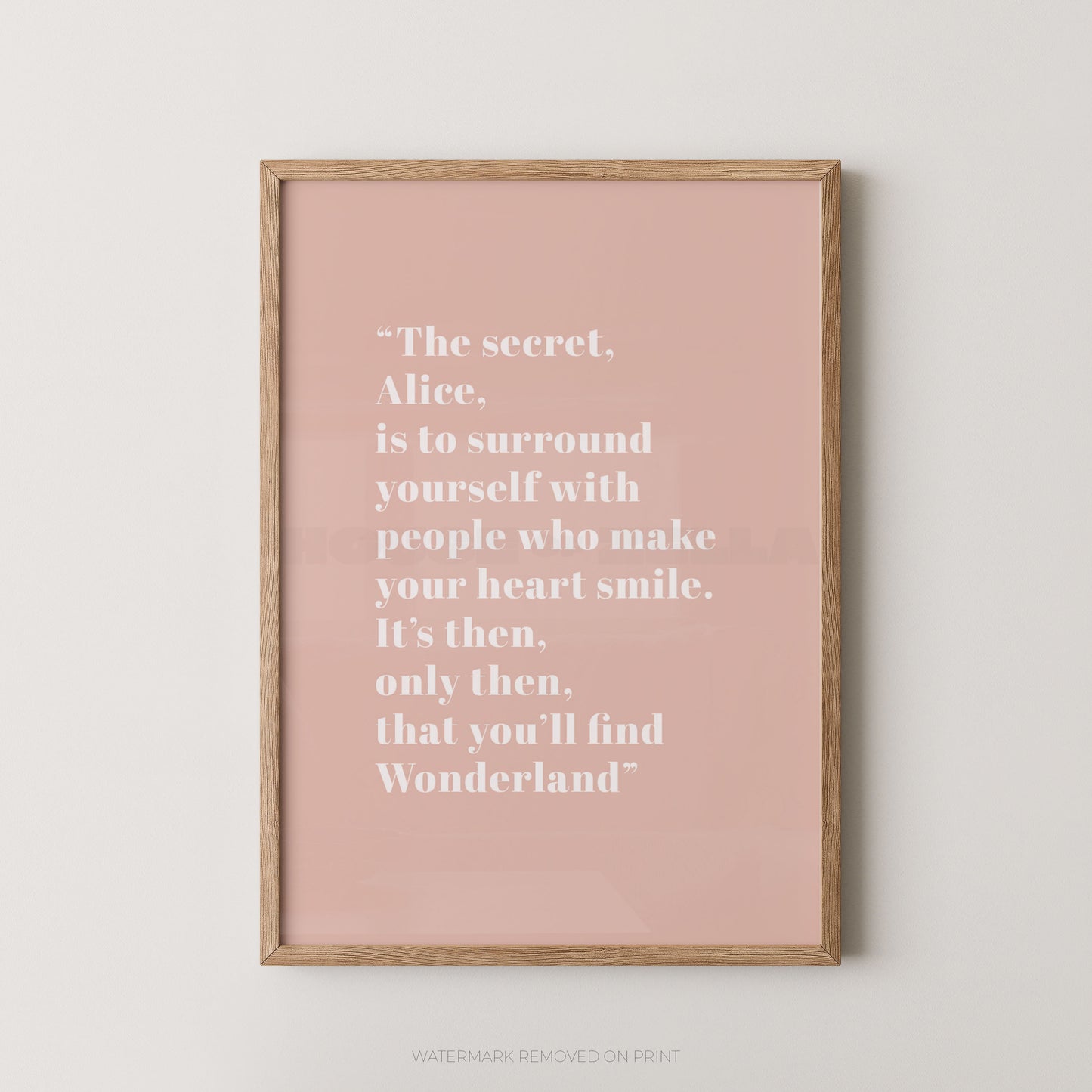 Framed pink poster with a quote on a white wall