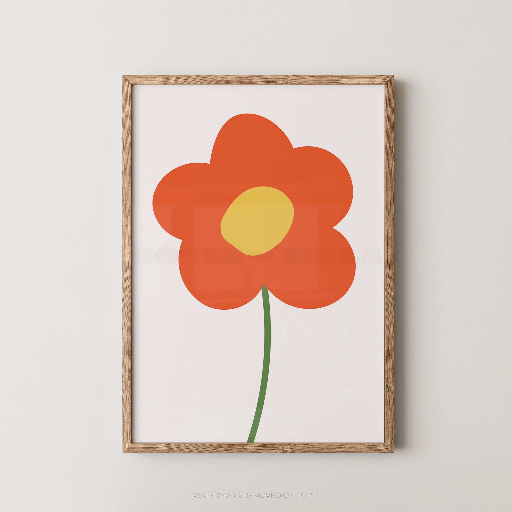 Framed minimalist floral wall art featuring a stylized orange flower with a yellow center and green stem on a white background, set in a light natural wood frame against a neutral wall.