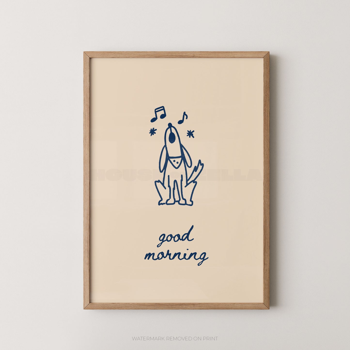 A framed art print featuring a navy blue line drawing of a dog with musical notes and the text 'good morning' on a warm cream background, enclosed in a light wood frame against a neutral wall.