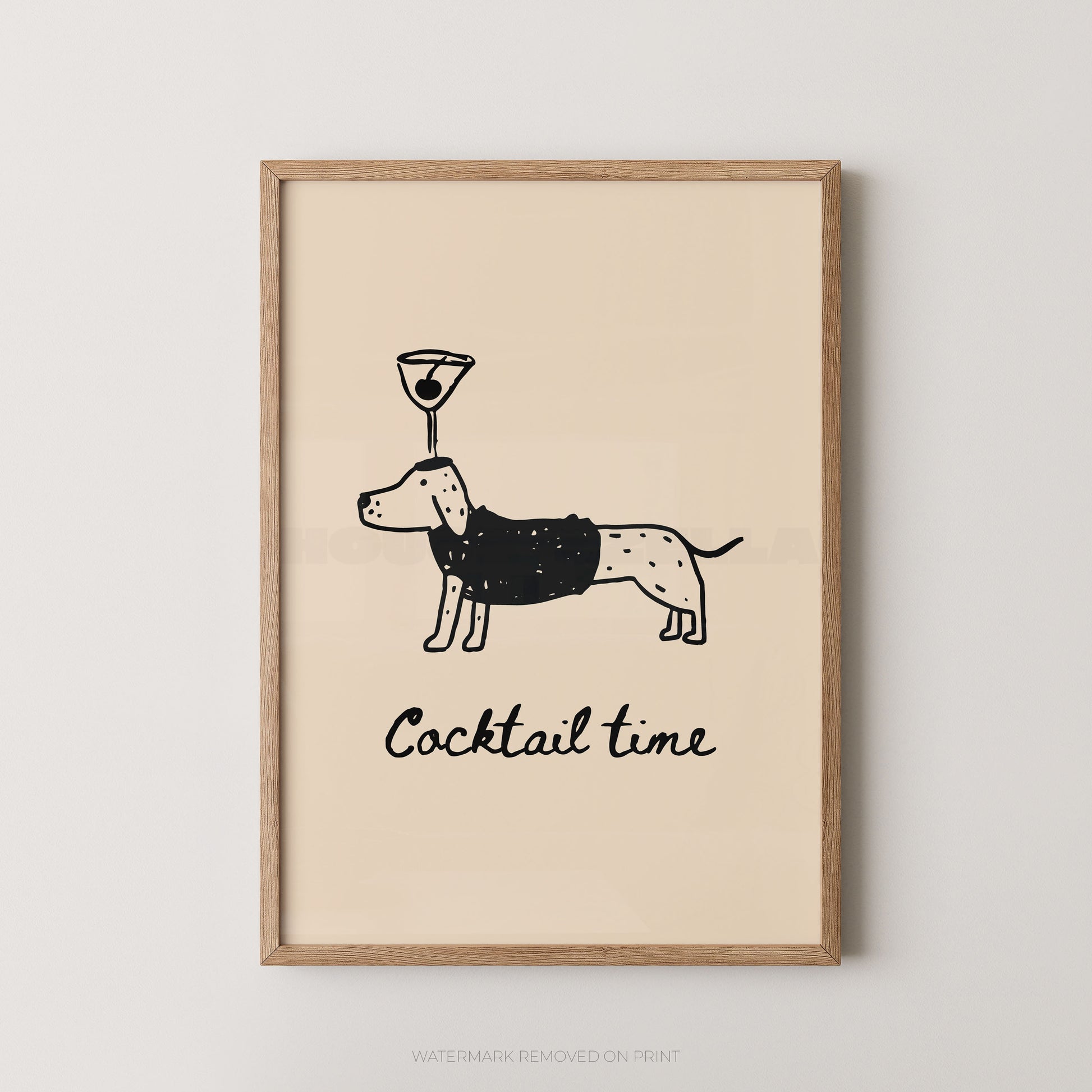 Framed wall art print with a minimalist black line drawing of a dachshund wearing a martini glass on its head, above the words 'Cocktail time' in black script, shown in a light wood frame against a light gray wall.