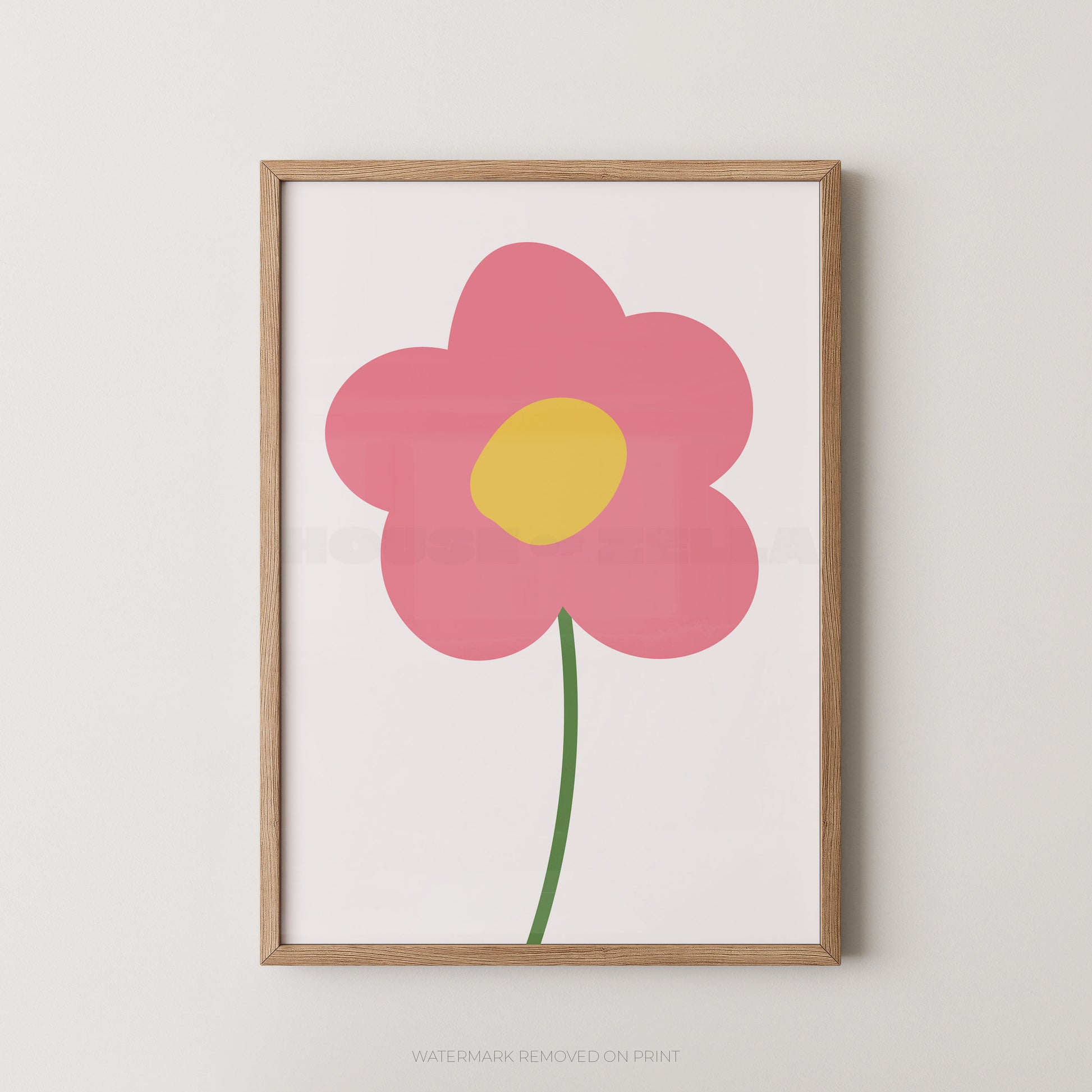 Framed minimalist floral wall art featuring a pink flower with a yellow center and green stem on a white background, set in a light natural wood frame against a neutral wall.