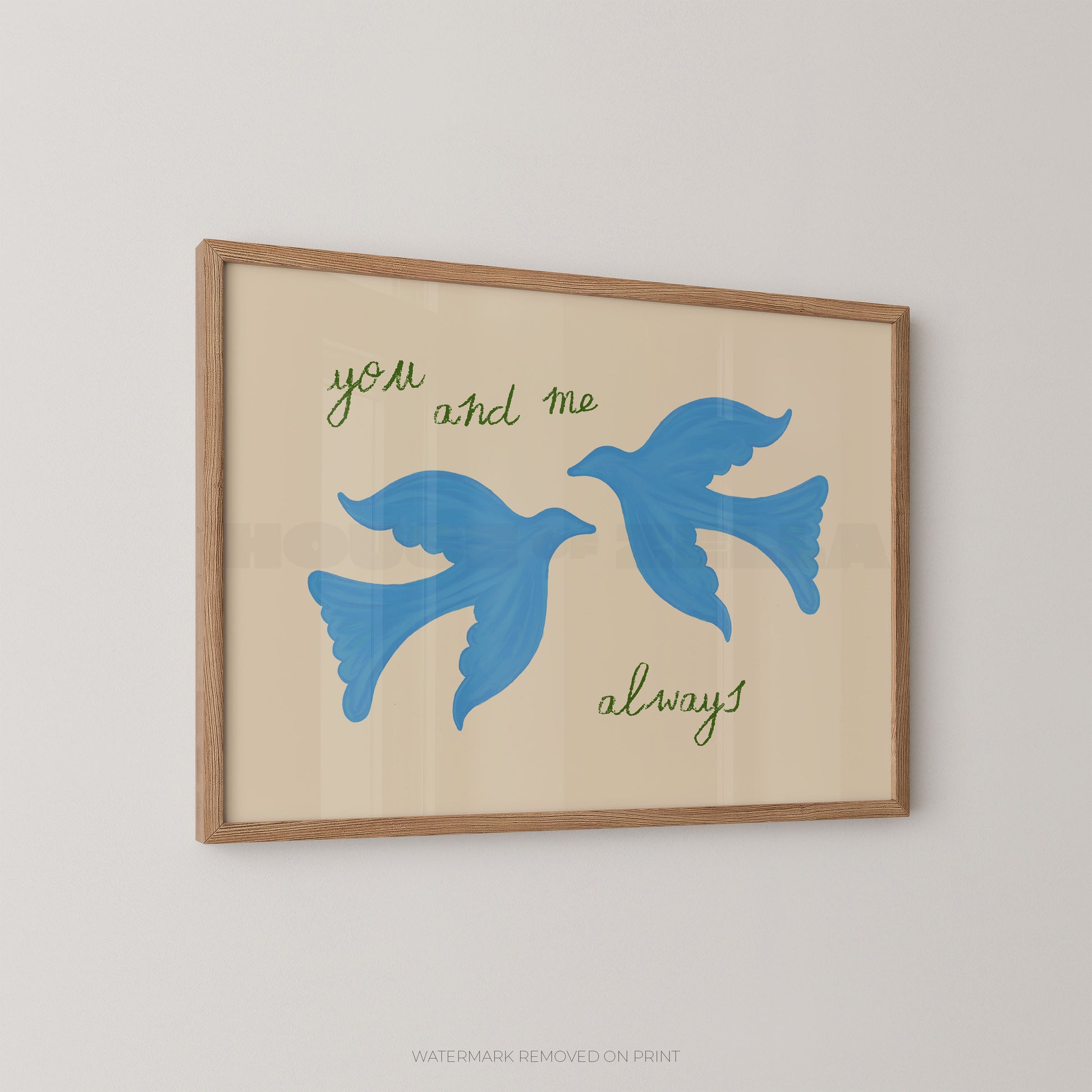 Framed wall art print with two blue flying birds and the words 'you and me always' in green script on a warm beige background, shown hanging on a light gray wall.