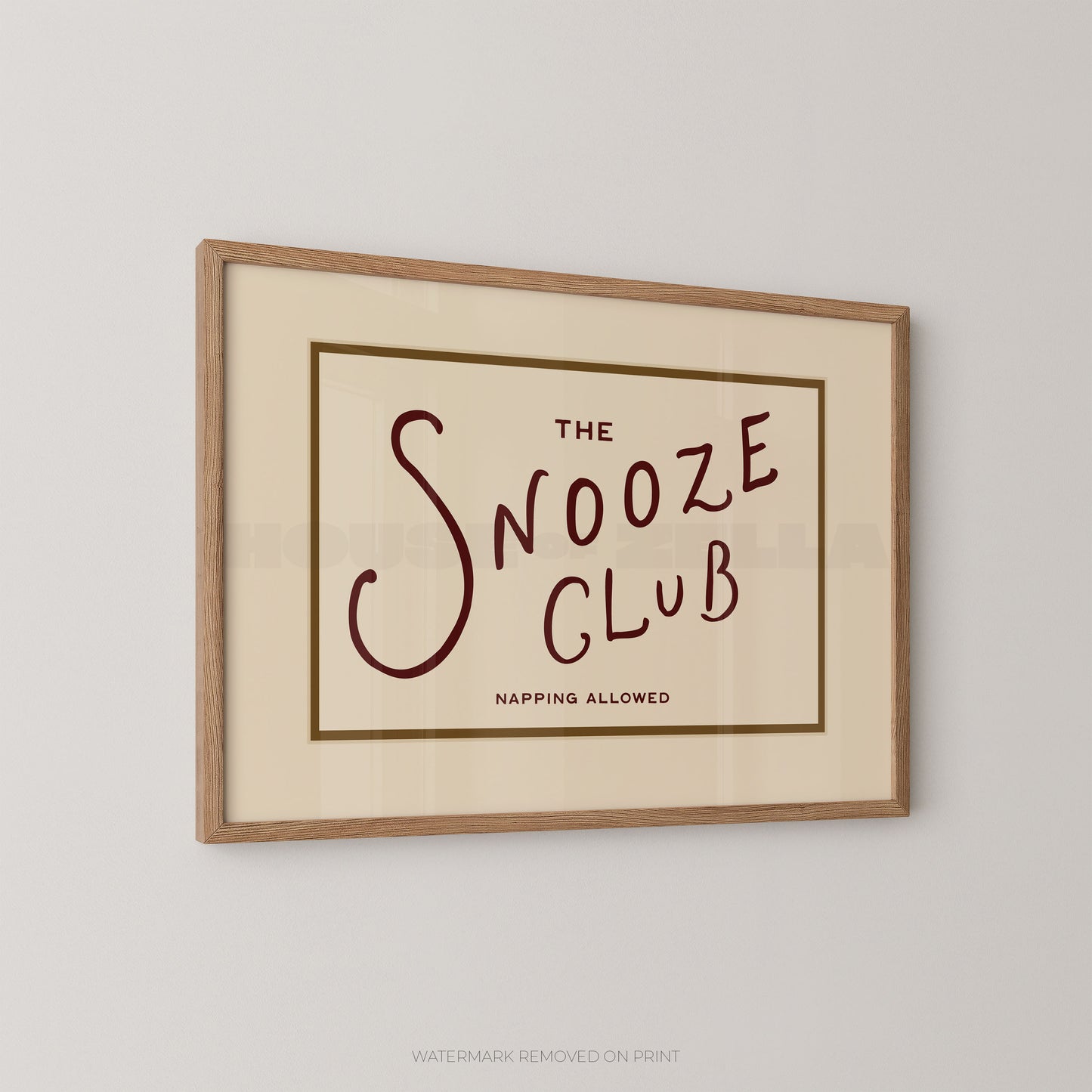 Framed print with 'The Snooze Club' text on a beige background