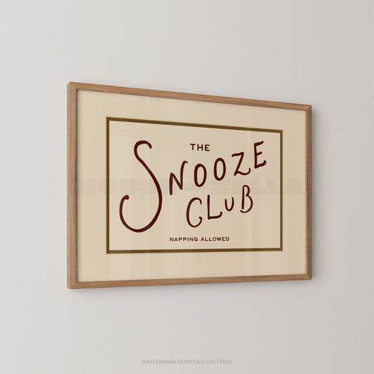 Framed print with 'The Snooze Club' text on a beige background