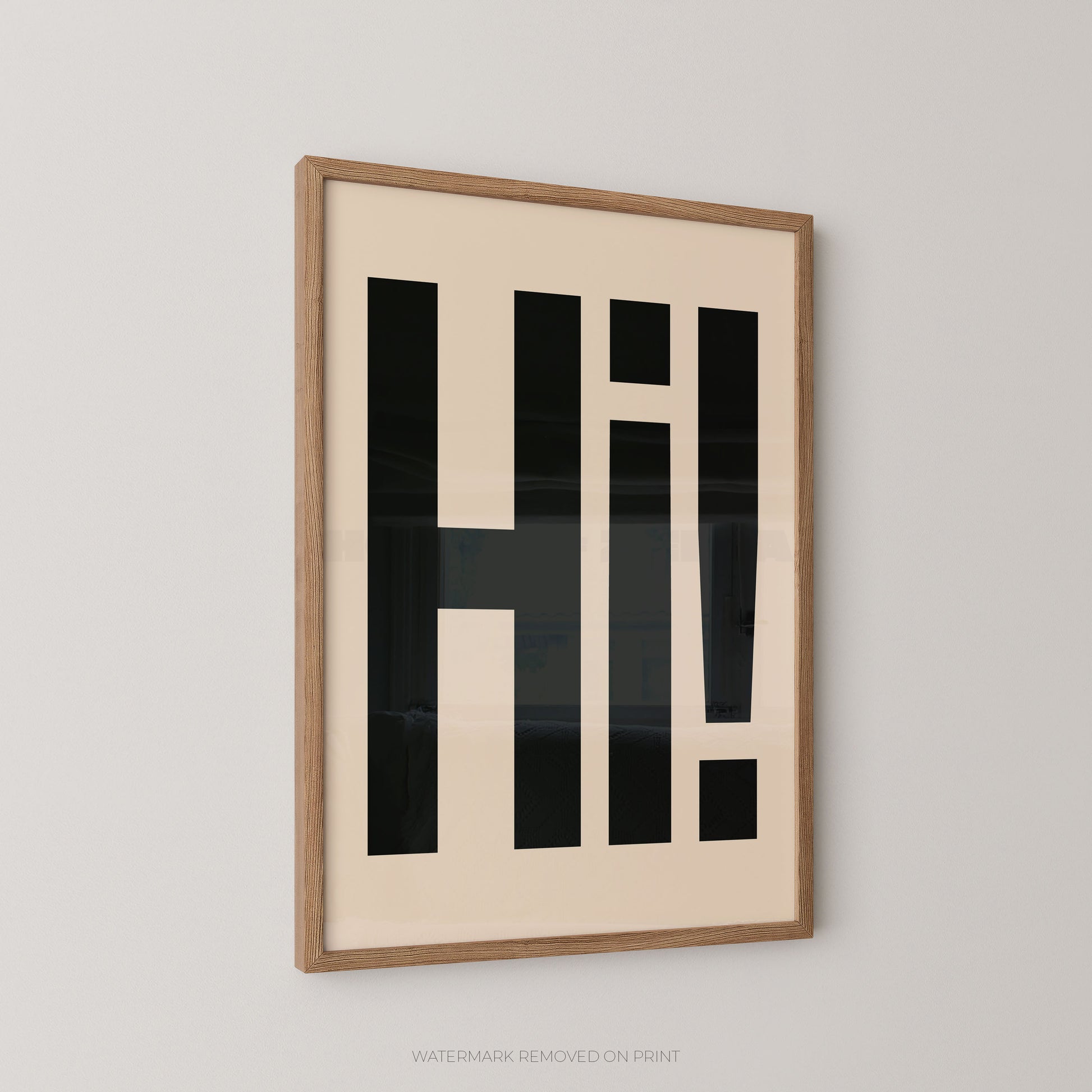 Framed wall art featuring bold black geometric lettering spelling 'HI!' on a cream background, shown hanging on a light gray wall.