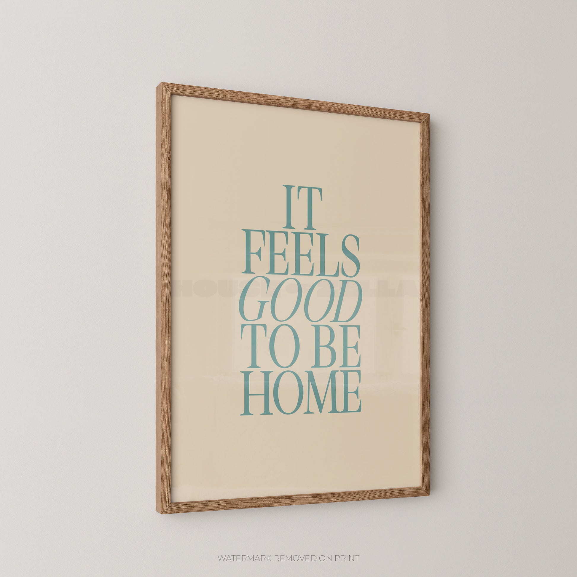 Framed poster with 'It Feels Good to Be Home' text on a beige background