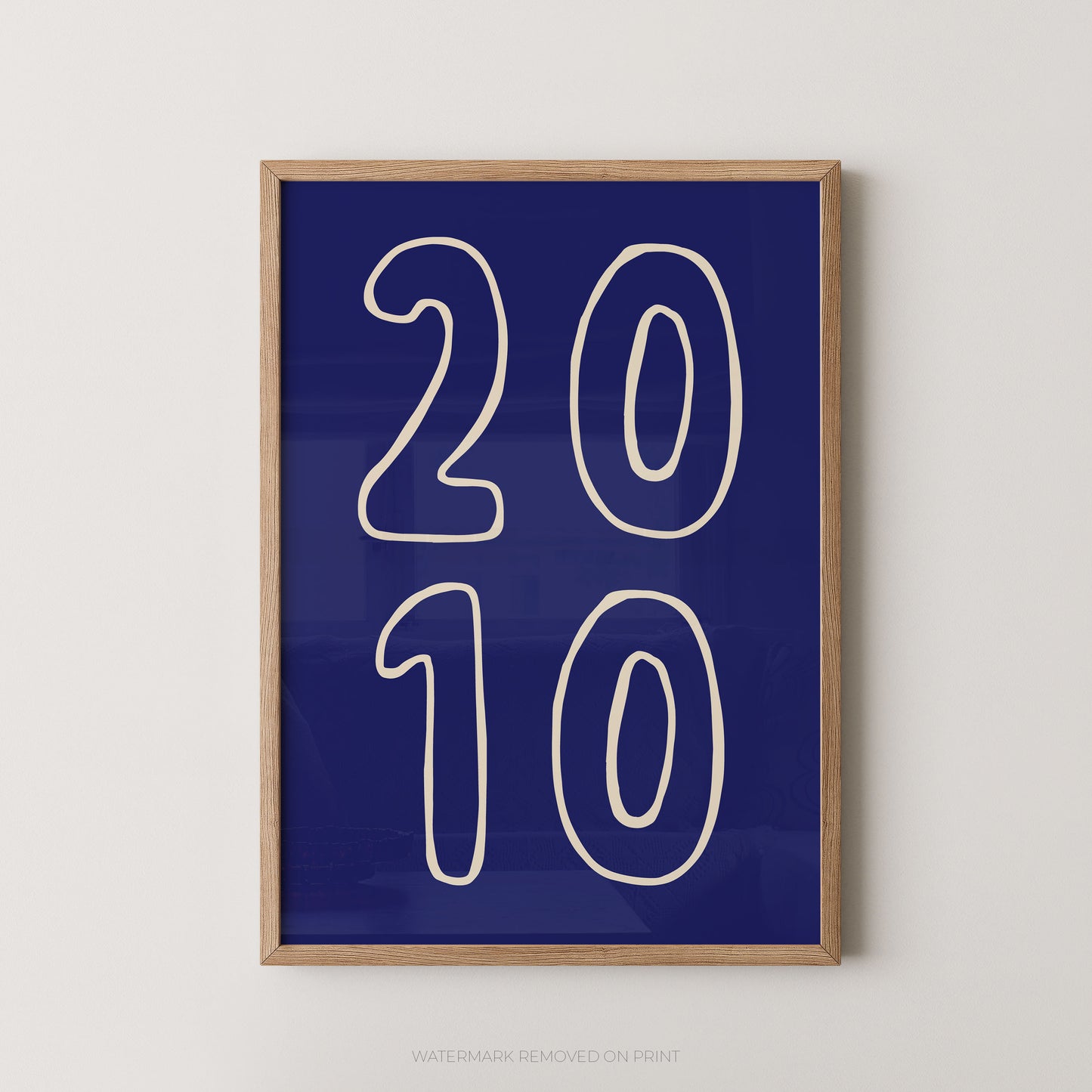 Framed wall art print with large white outlined numbers '2010' on a deep blue background, shown hanging against a light neutral wall.