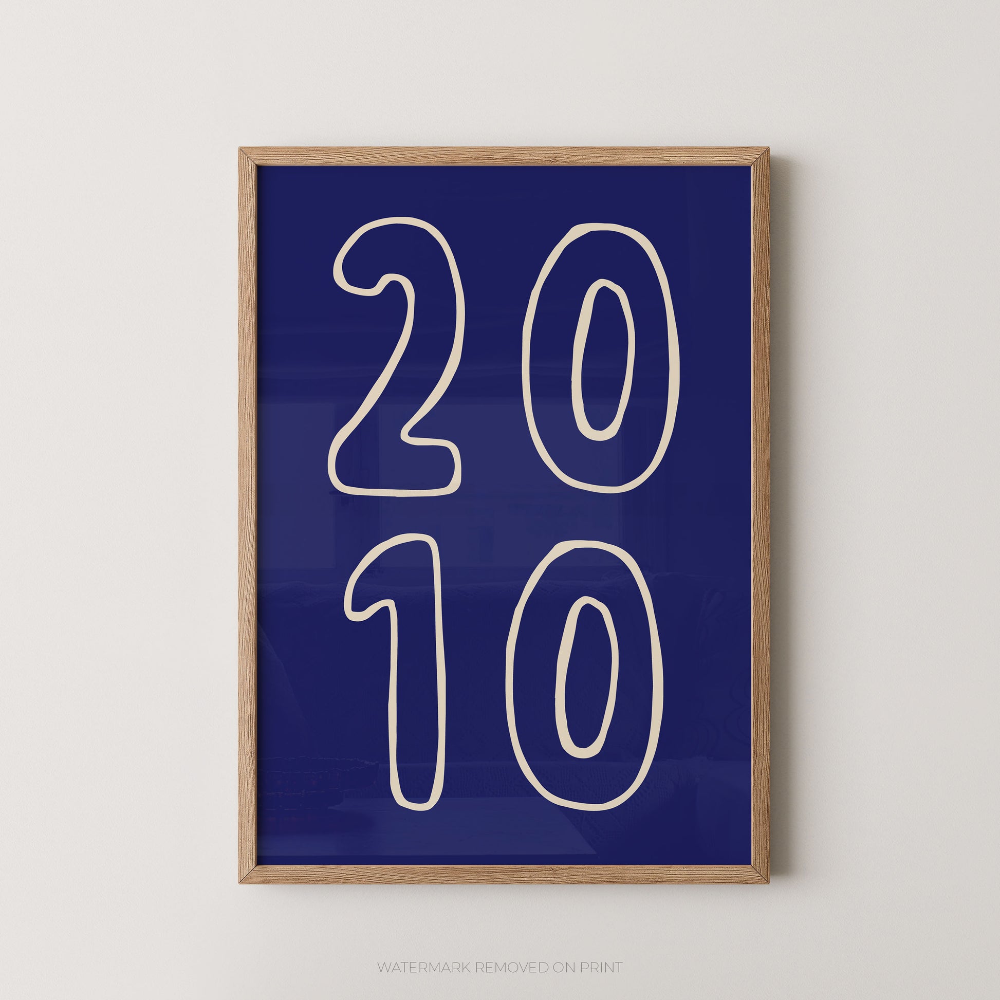 Framed wall art print with large white outlined numbers '2010' on a deep blue background, shown hanging against a light neutral wall.