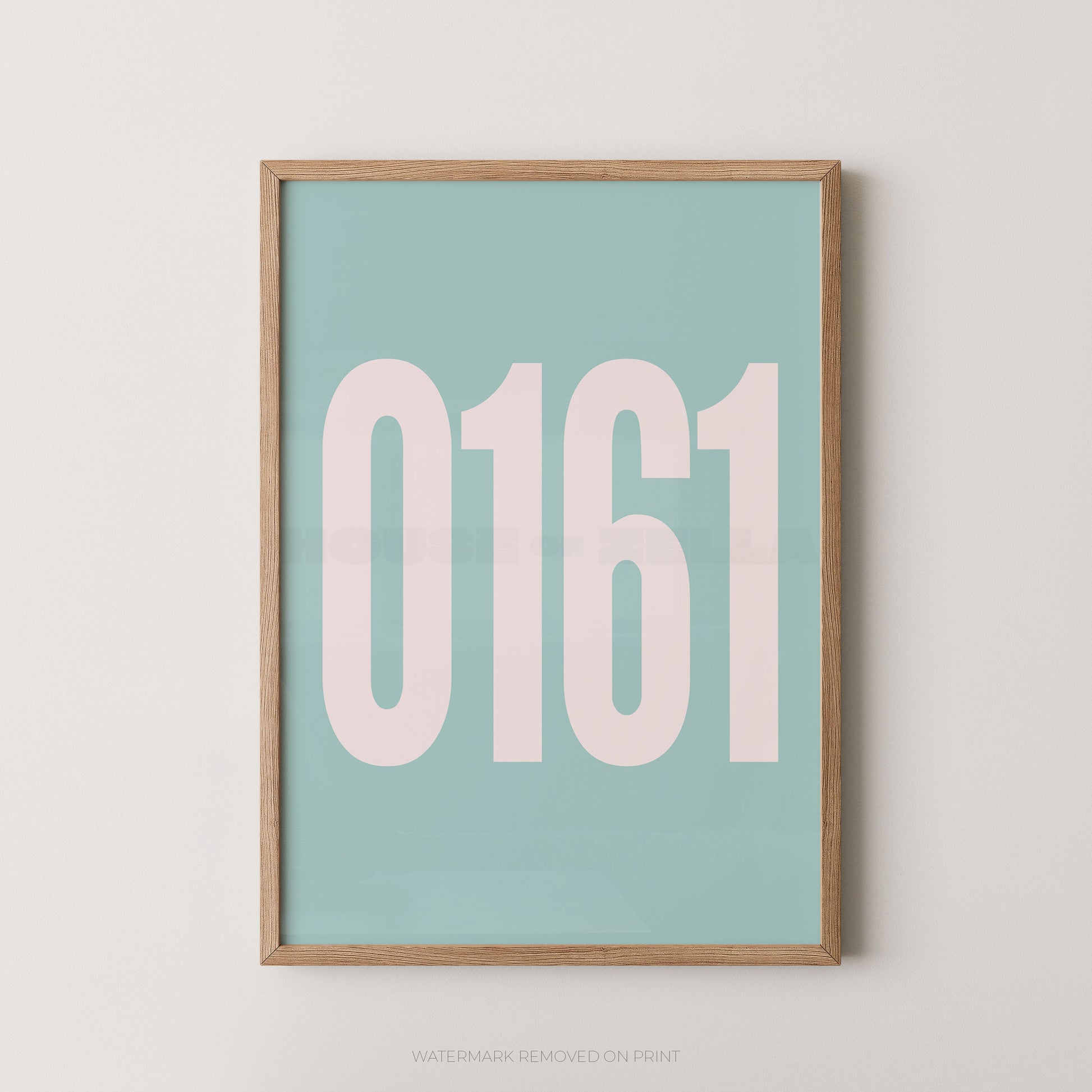 A framed minimalist art print featuring the numbers '0161' in a pale pink font on a light teal background, enclosed in a natural wood frame against a neutral off-white wall.
