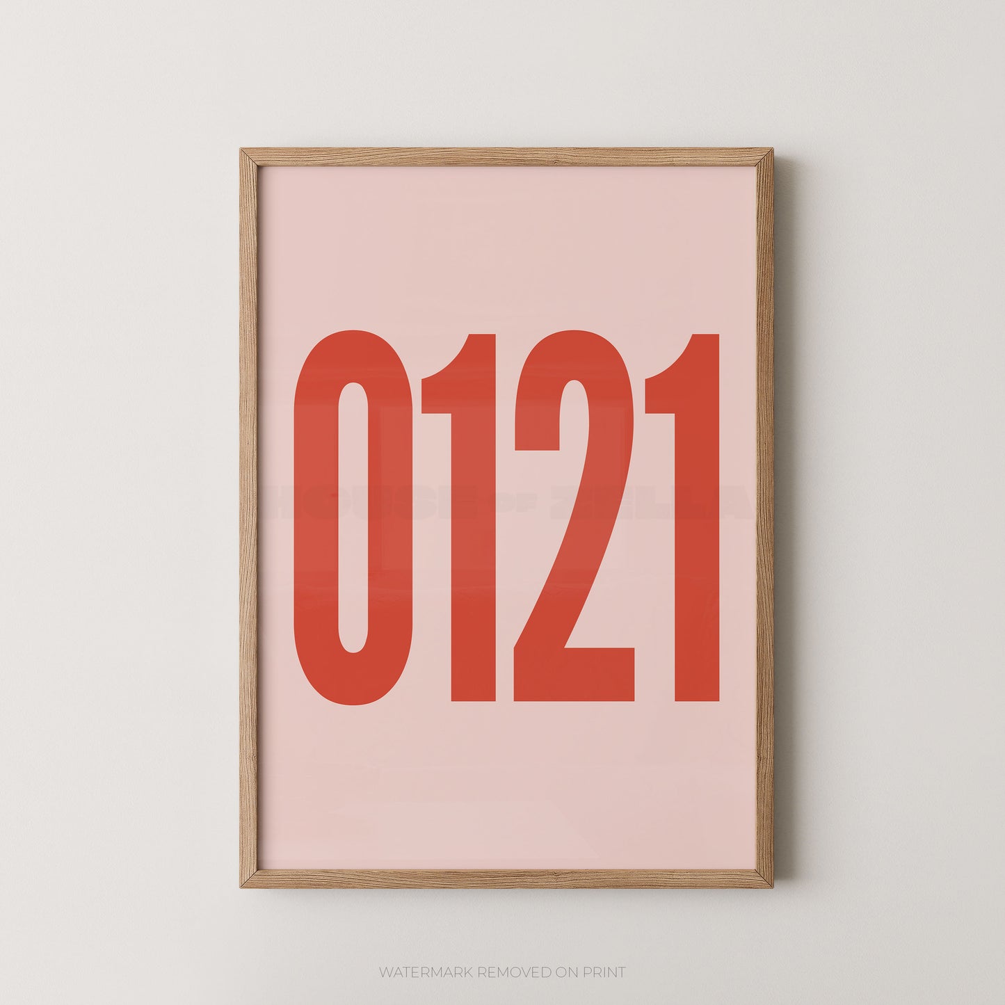 A framed minimalist art print featuring '0121' in red on a pink background, enclosed in a natural wood frame.