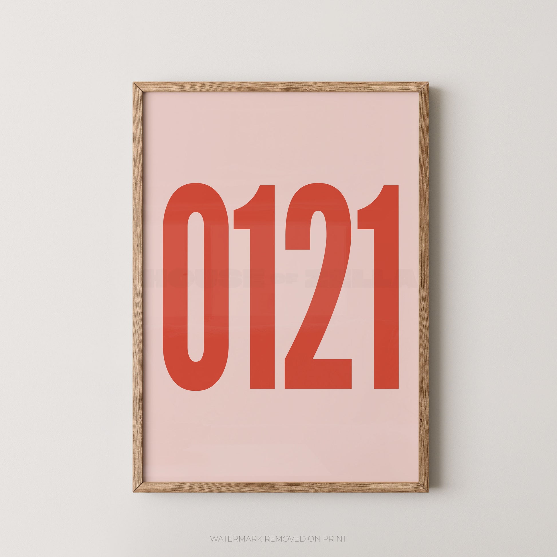A framed minimalist art print featuring '0121' in red on a pink background, enclosed in a natural wood frame.