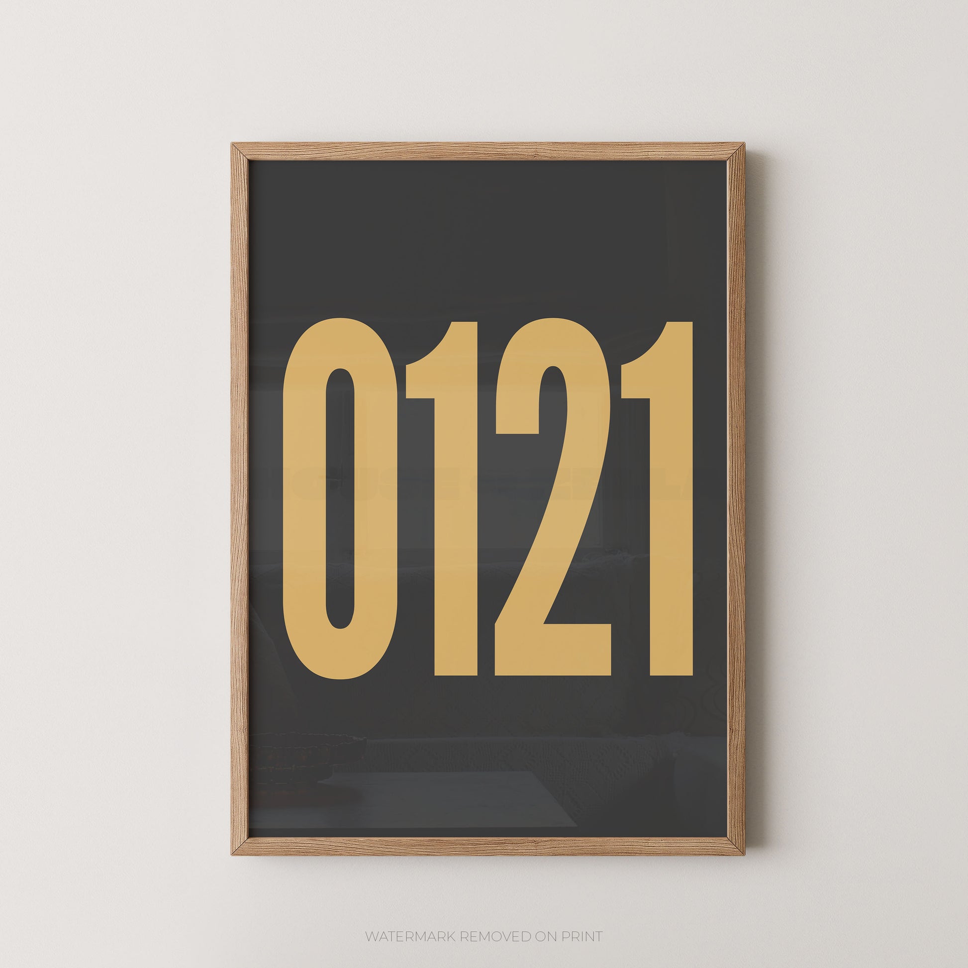 Framed wall art print with '0121' in large gold font on a dark charcoal background, framed against a light wall.