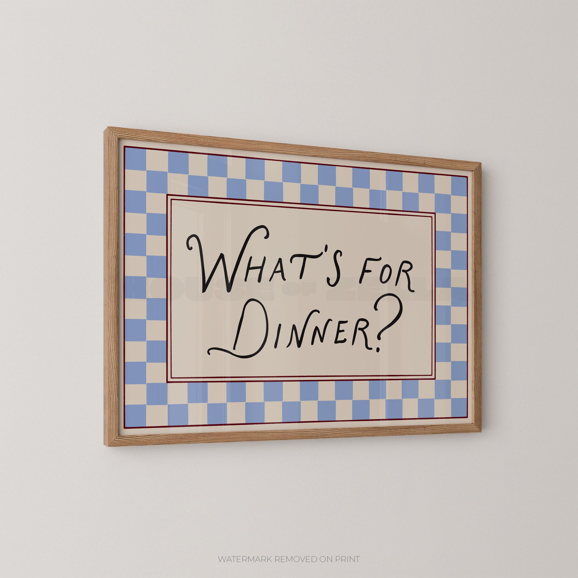 Framed checkered sign with 'What's for Dinner?' text on a plain wall.