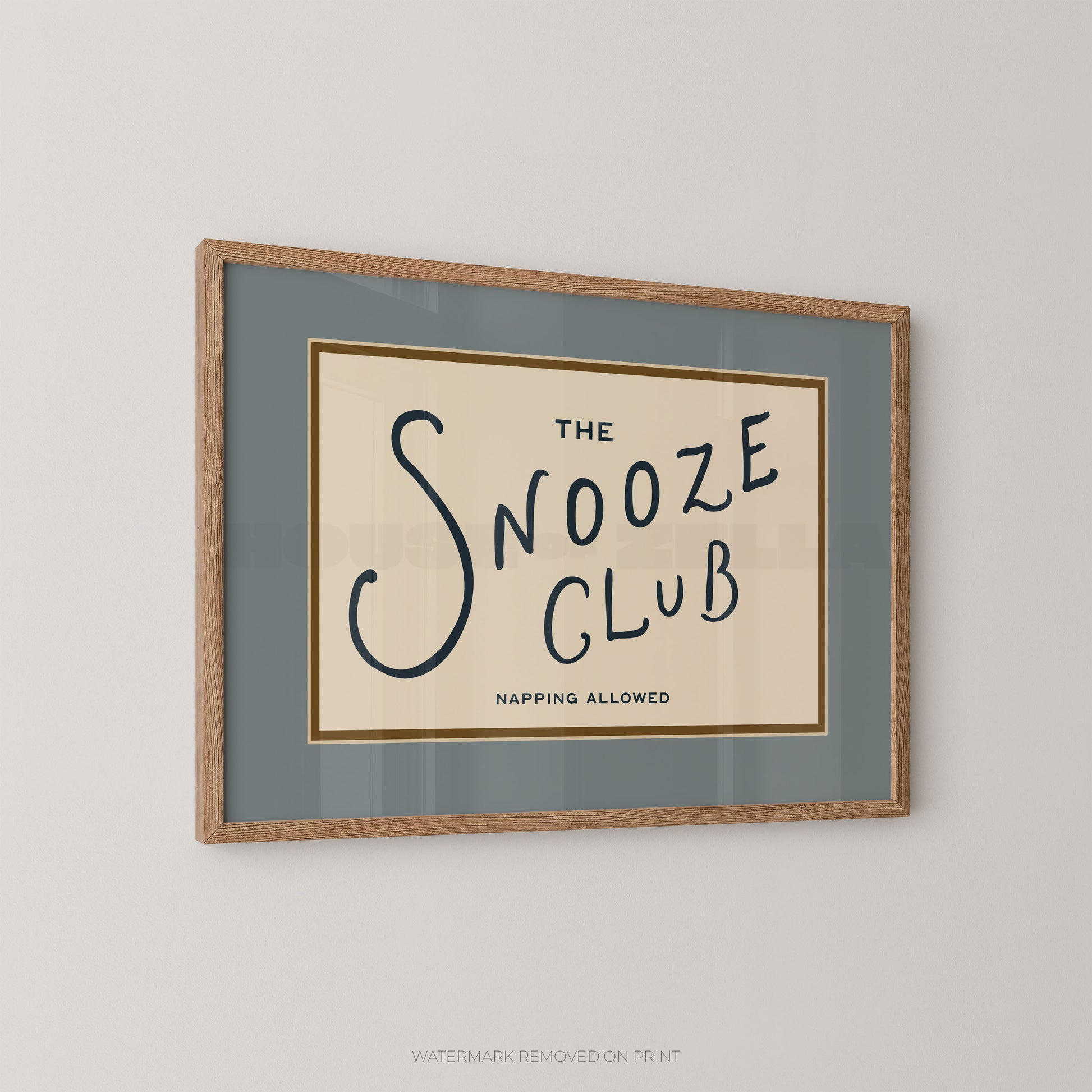 Framed print with 'The Snooze Club' text on a beige background