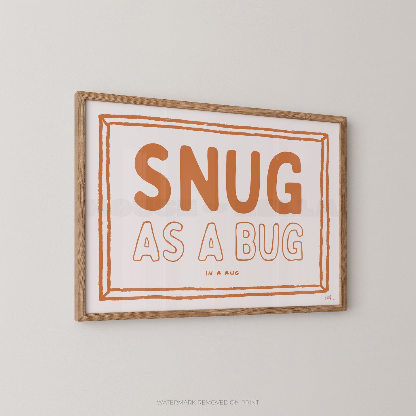 Framed print with 'SNUG AS A BUG' text on a plain wall