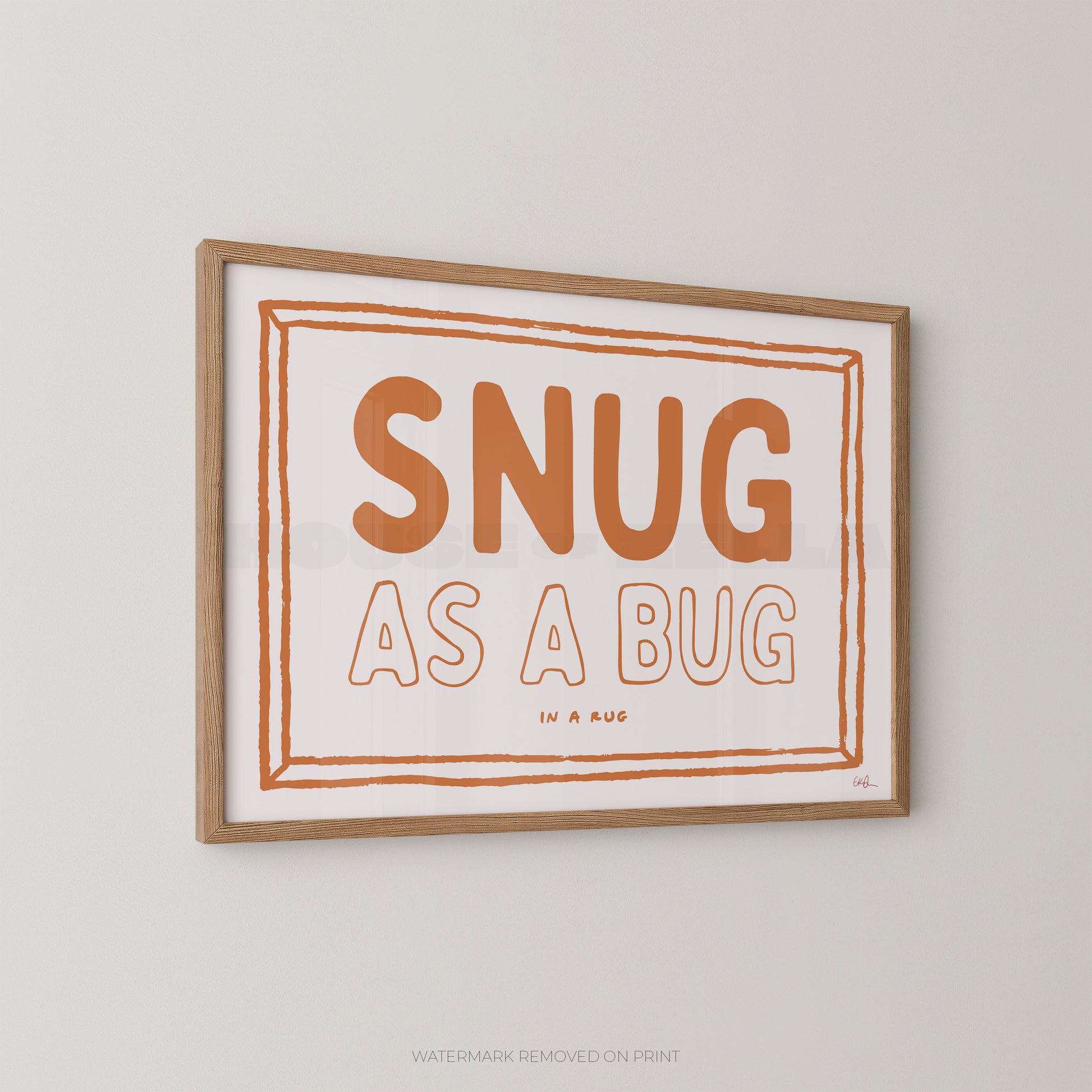 Framed print with 'SNUG AS A BUG' text on a plain wall