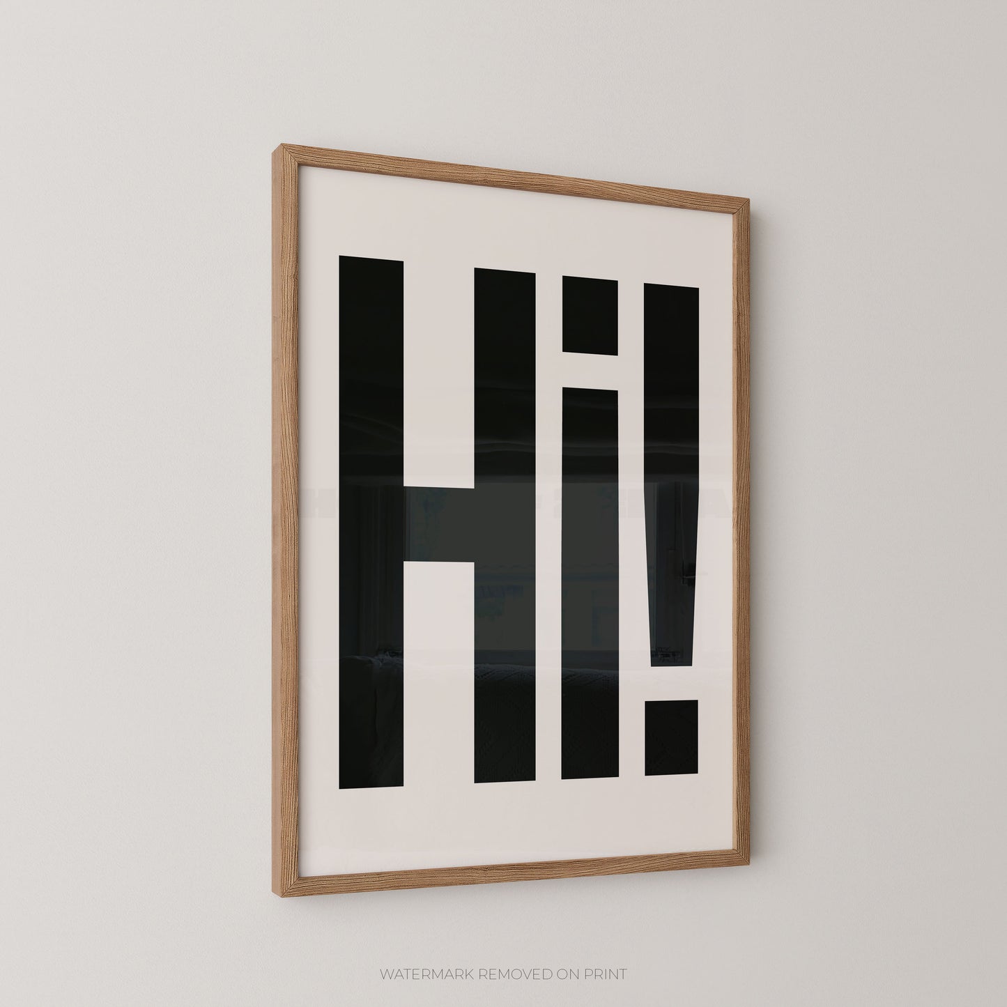 Framed wall art featuring bold black geometric lettering spelling 'Hi!' on a white background, set in a light natural wood frame against a neutral light gray wall.