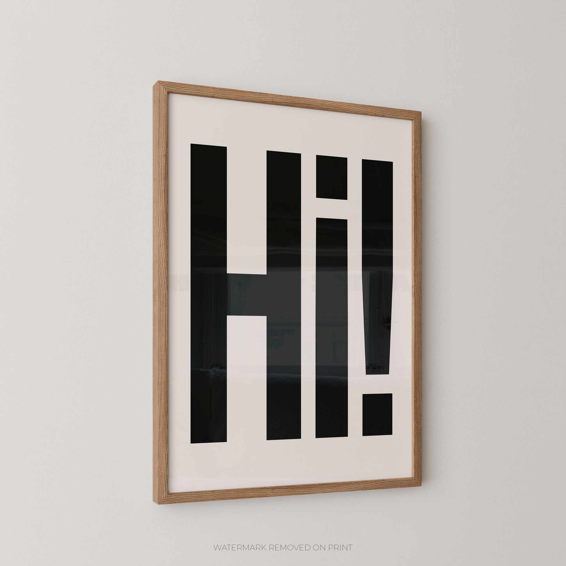 Framed wall art featuring bold black geometric lettering spelling 'Hi!' on a white background, set in a light natural wood frame against a neutral light gray wall.