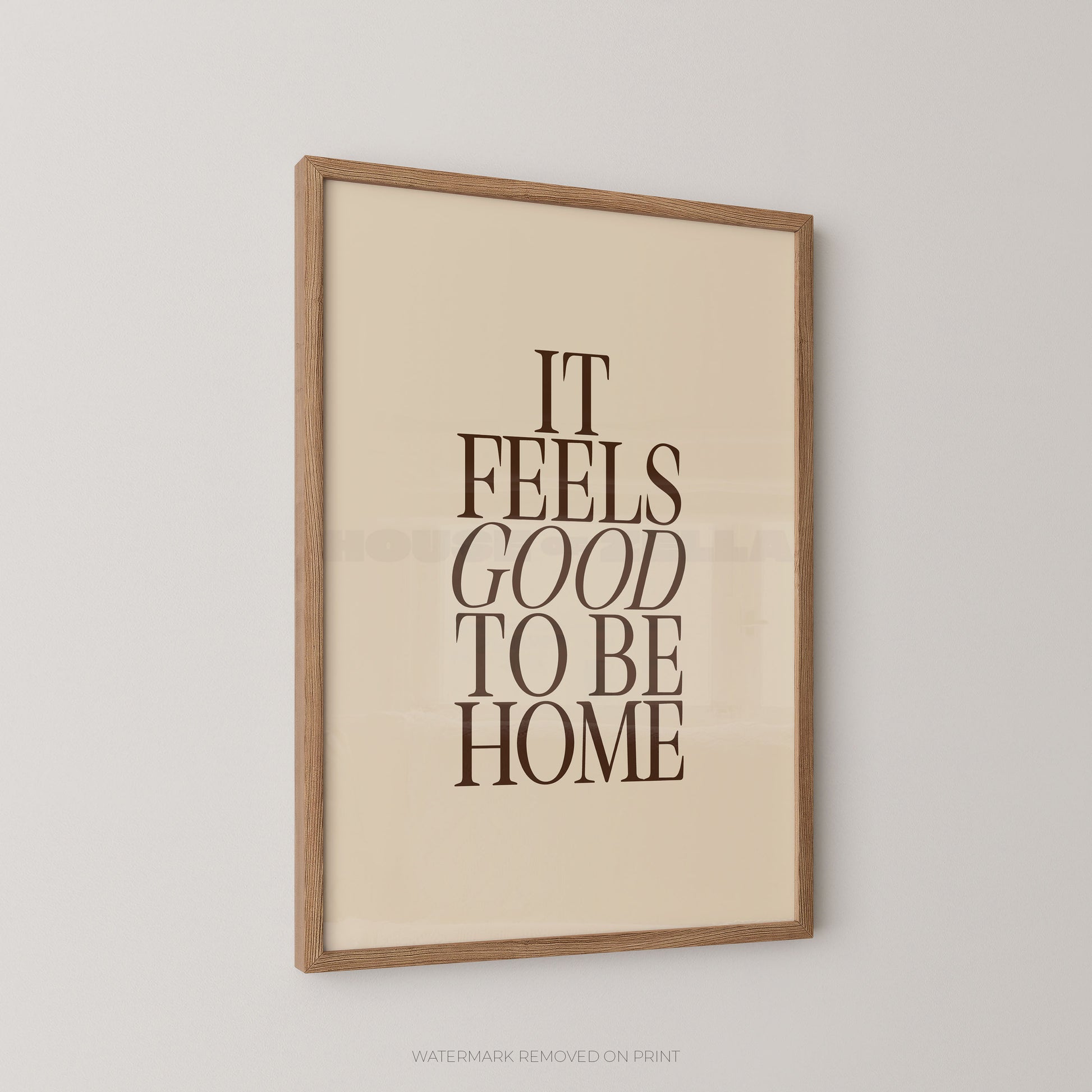 Framed poster with 'It Feels Good to Be Home' text on a beige background