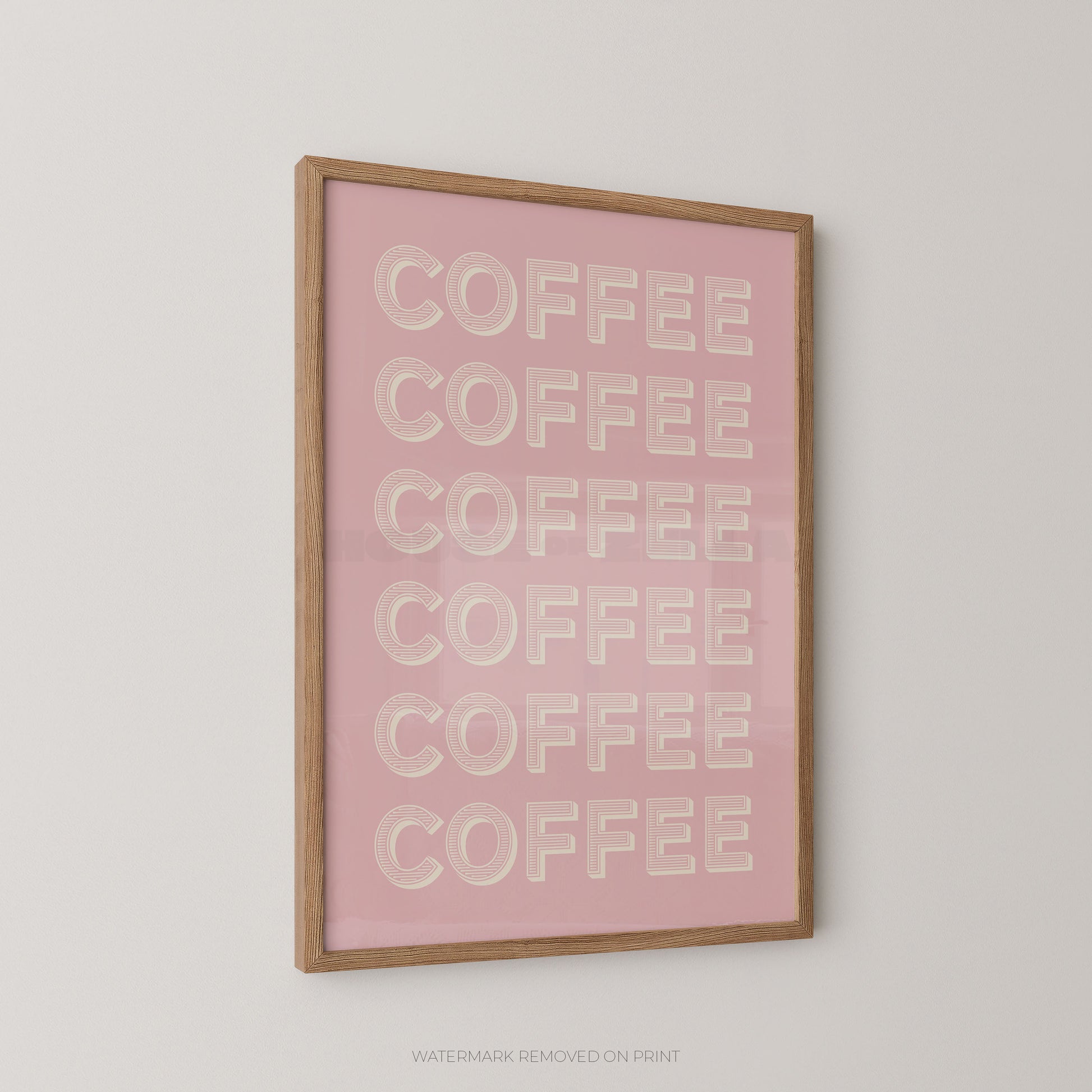 A framed wall art print featuring the word 'COFFEE' repeated six times in raised cream lettering on a soft pink background, enclosed in a light natural wood frame and shown hanging on a light gray wall.