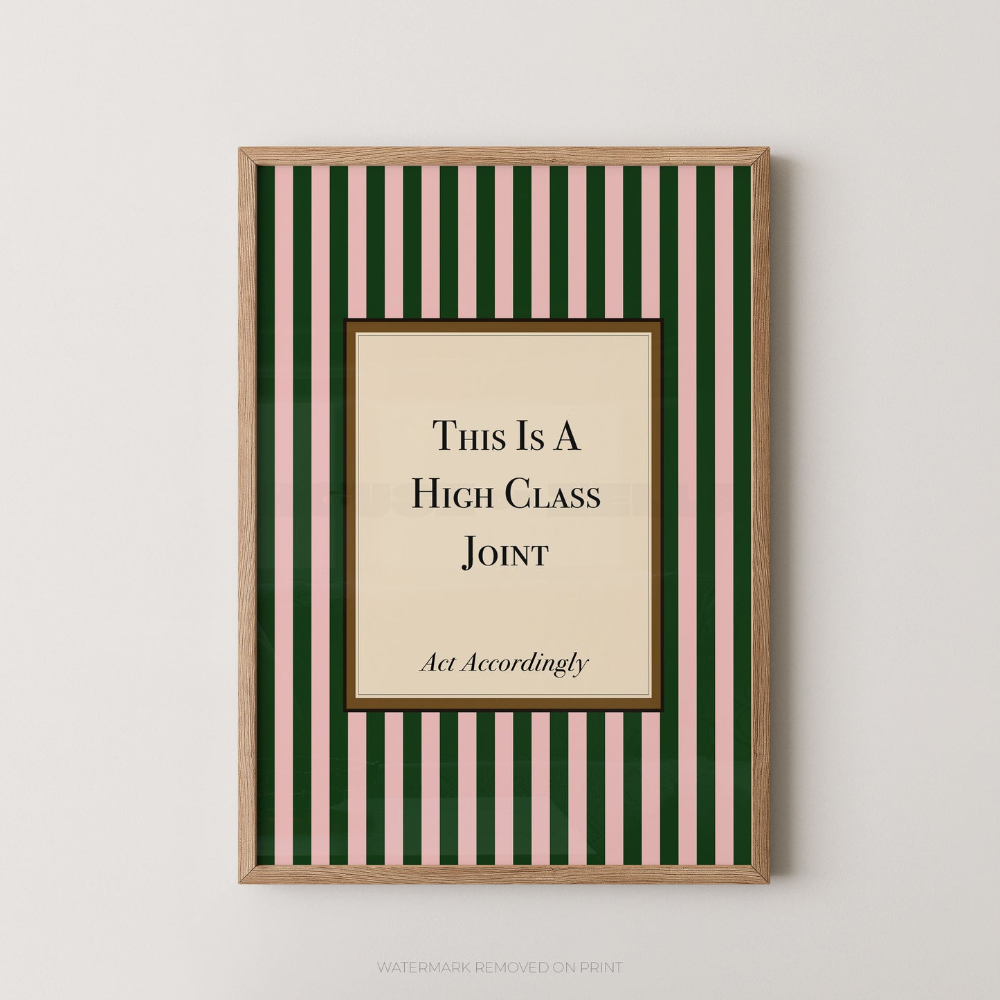 A framed humorous wall art print featuring a beige central panel with the text 'This Is A High Class Joint' and 'Act Accordingly' on a background of dark green and light pink vertical stripes, enclosed in a light wood frame.