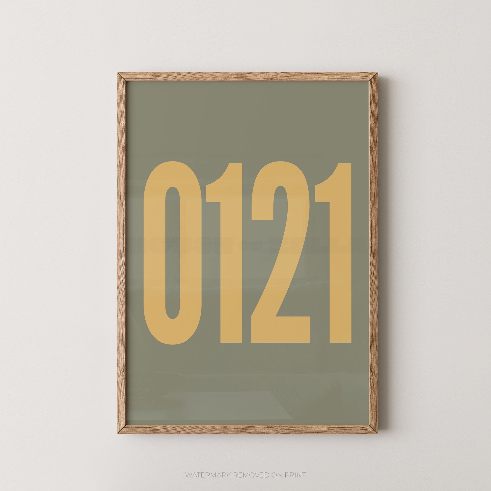 A framed minimalist art print featuring '0121' in gold on a greenbackground, enclosed in a natural wood frame.