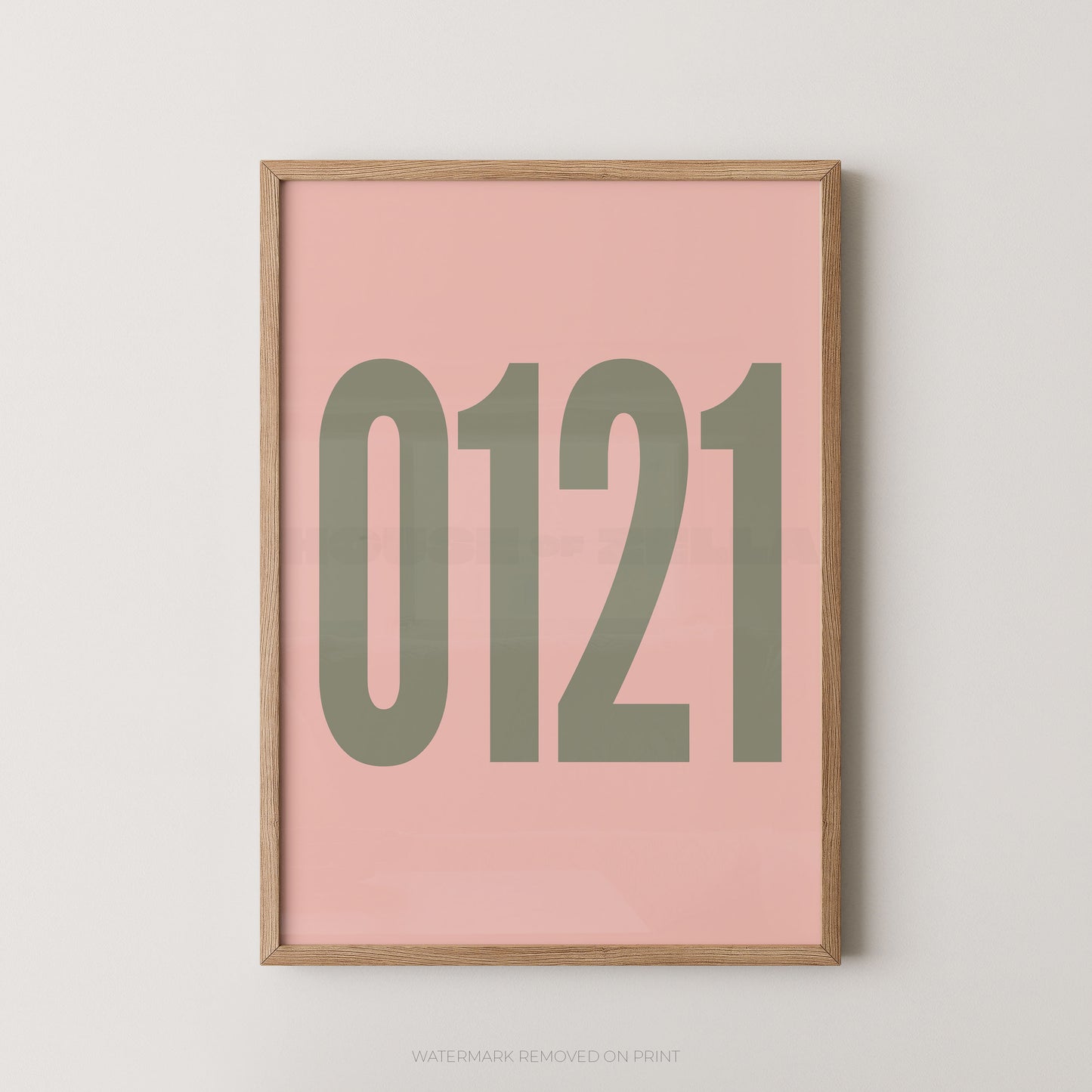 A framed minimalist art print featuring '0121' in gold on a light pink background, enclosed in a natural wood frame.