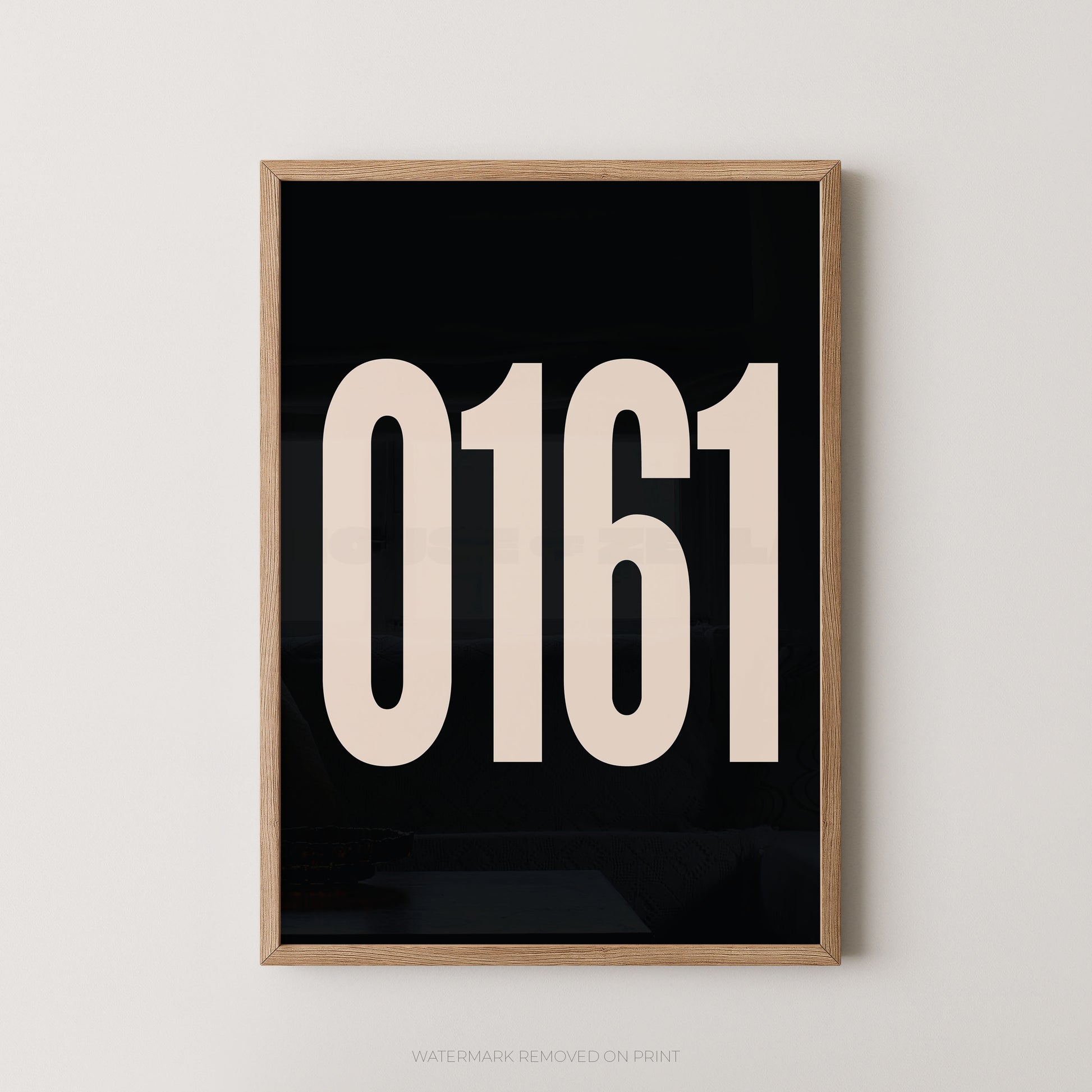 Framed minimalist wall art featuring the large cream-colored numbers '0161' on a solid black background, enclosed in a light natural wood frame and mounted on a neutral light gray wall.