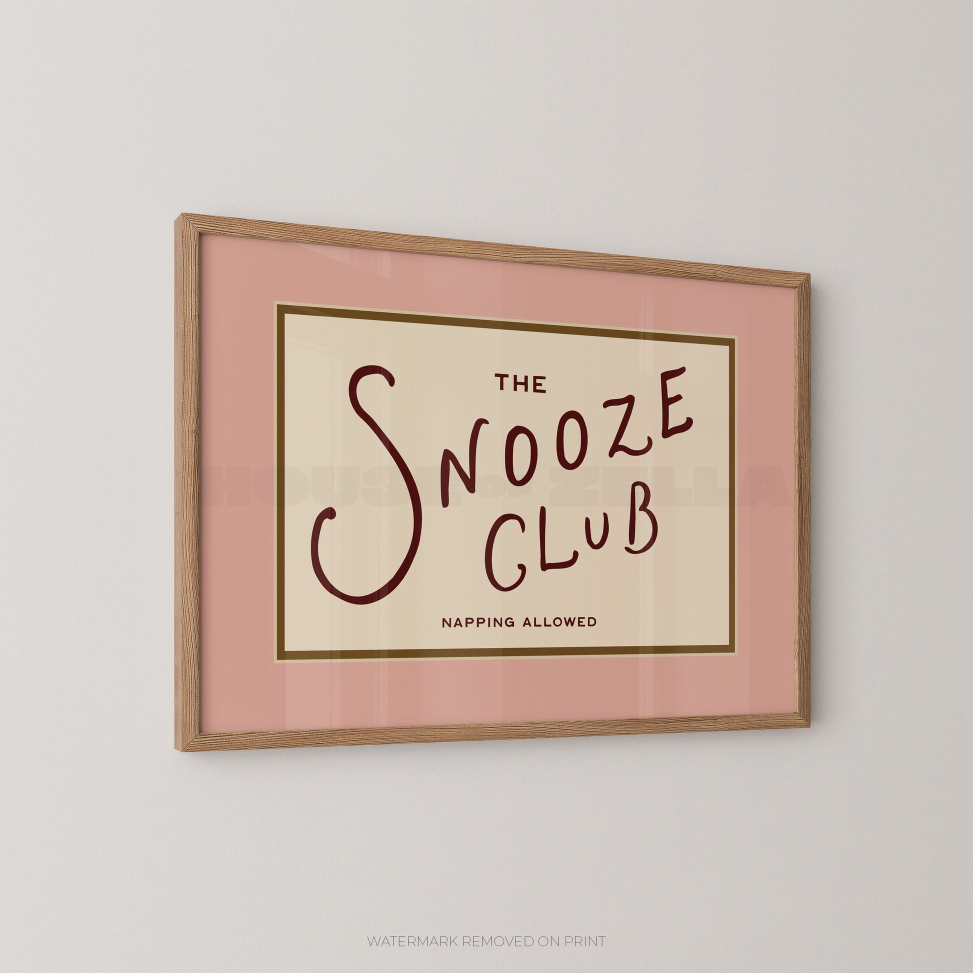 Framed artwork with 'The Snooze Club' text on a pink background