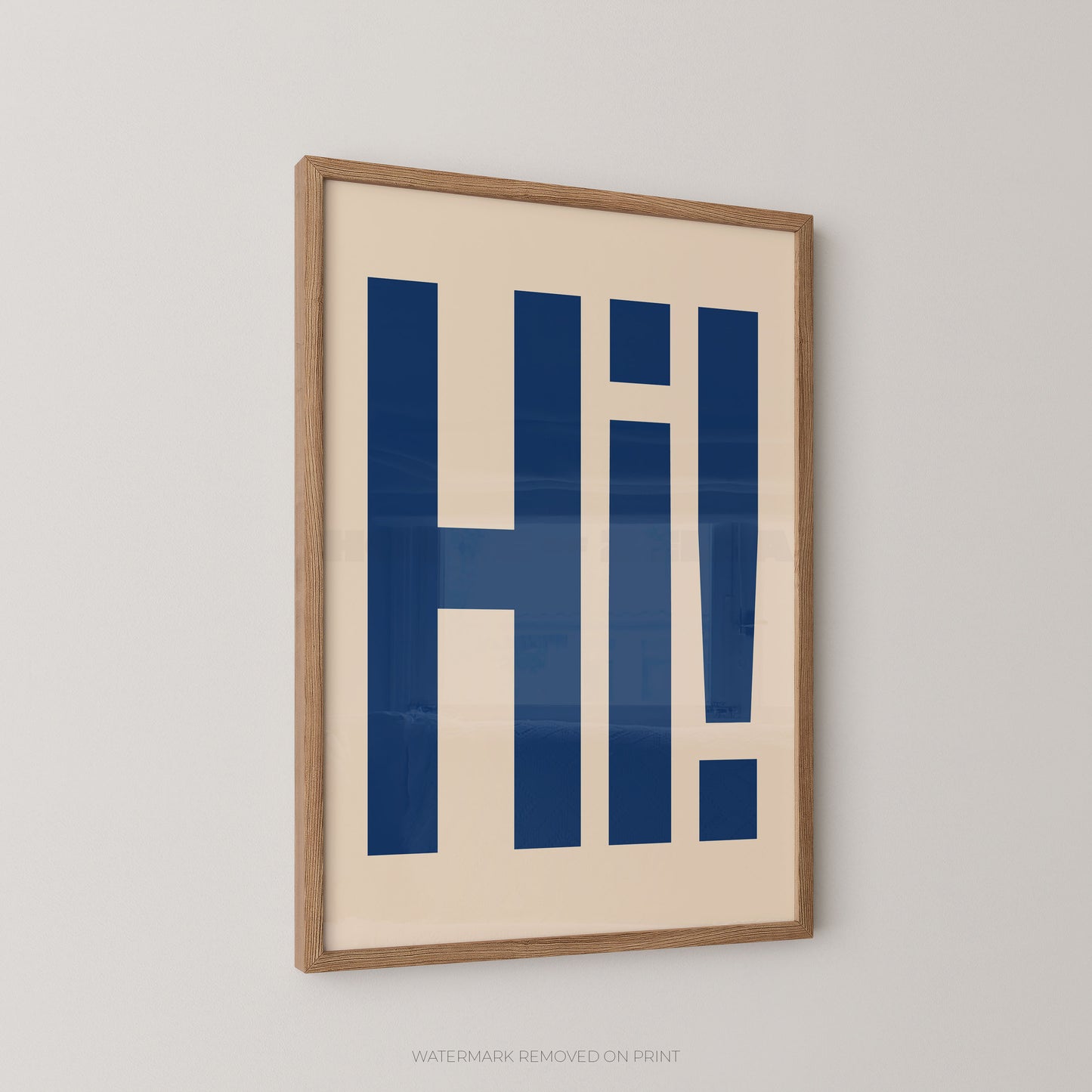 Framed typographic wall art featuring the word 'Hi!' in bold navy blue letters on a warm cream background, shown hanging on a light gray wall.