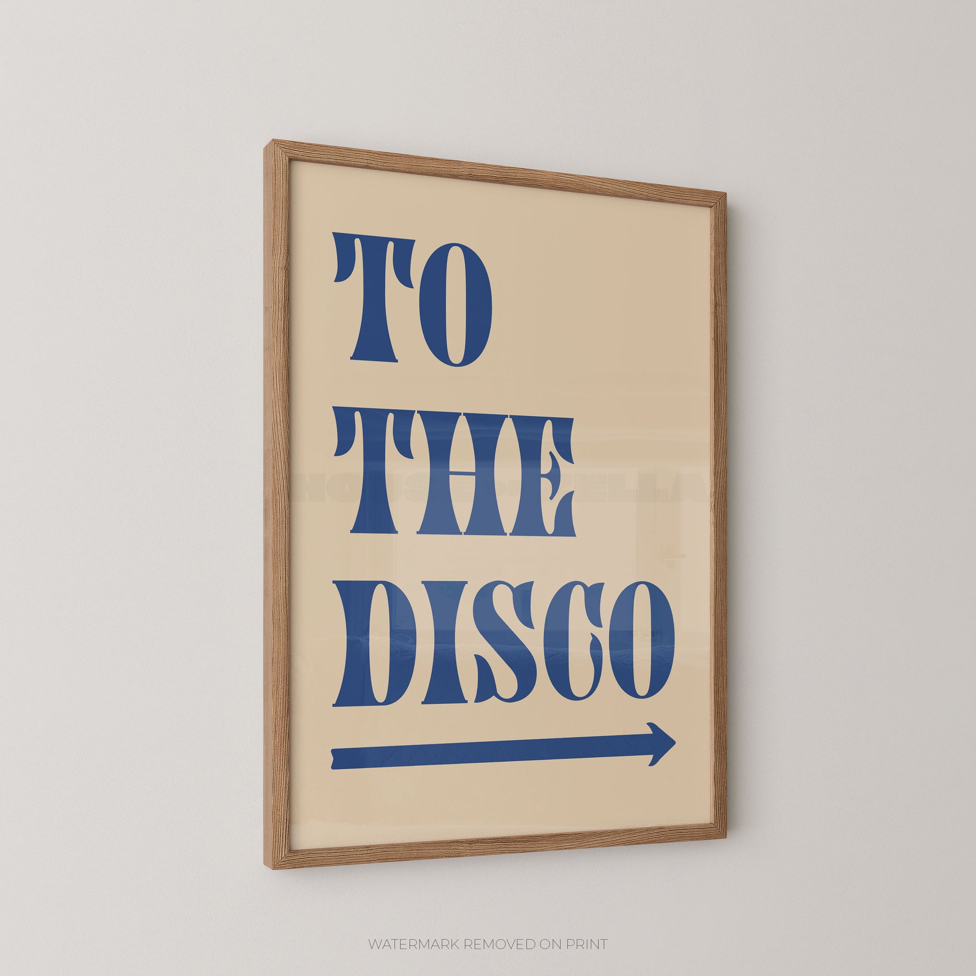Framed typographic wall art hanging on a light gray wall, with the words “TO THE DISCO” in large blue letters and a blue arrow on a cream background.