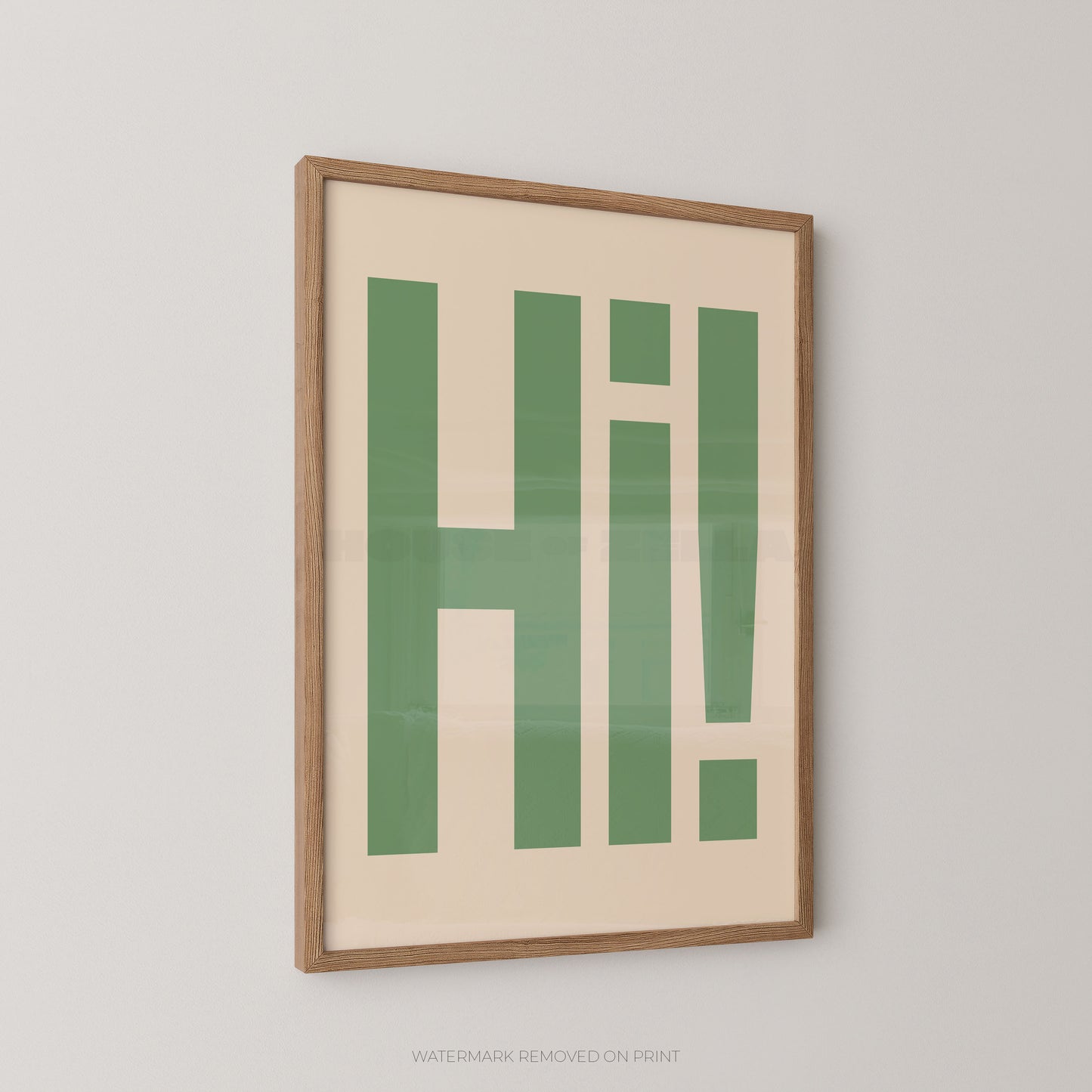 Framed typographic wall art featuring the word 'HI!' in bold green letters on a cream background, shown hanging on a light gray wall.