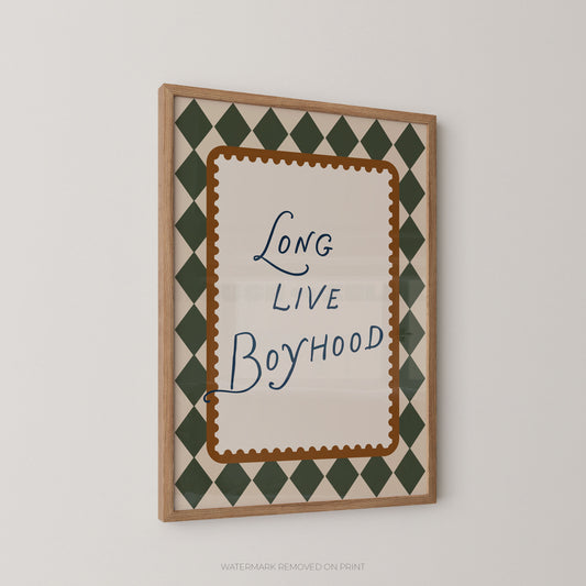 Framed wall art print with the phrase 'Long Live Boyhood' in blue script, surrounded by a brown scalloped inner border and a green-and-cream diamond pattern, shown hanging on a light gray wall.